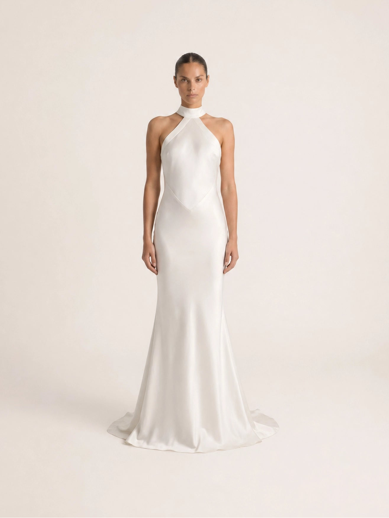 White halter-neck wedding dress on a plain background