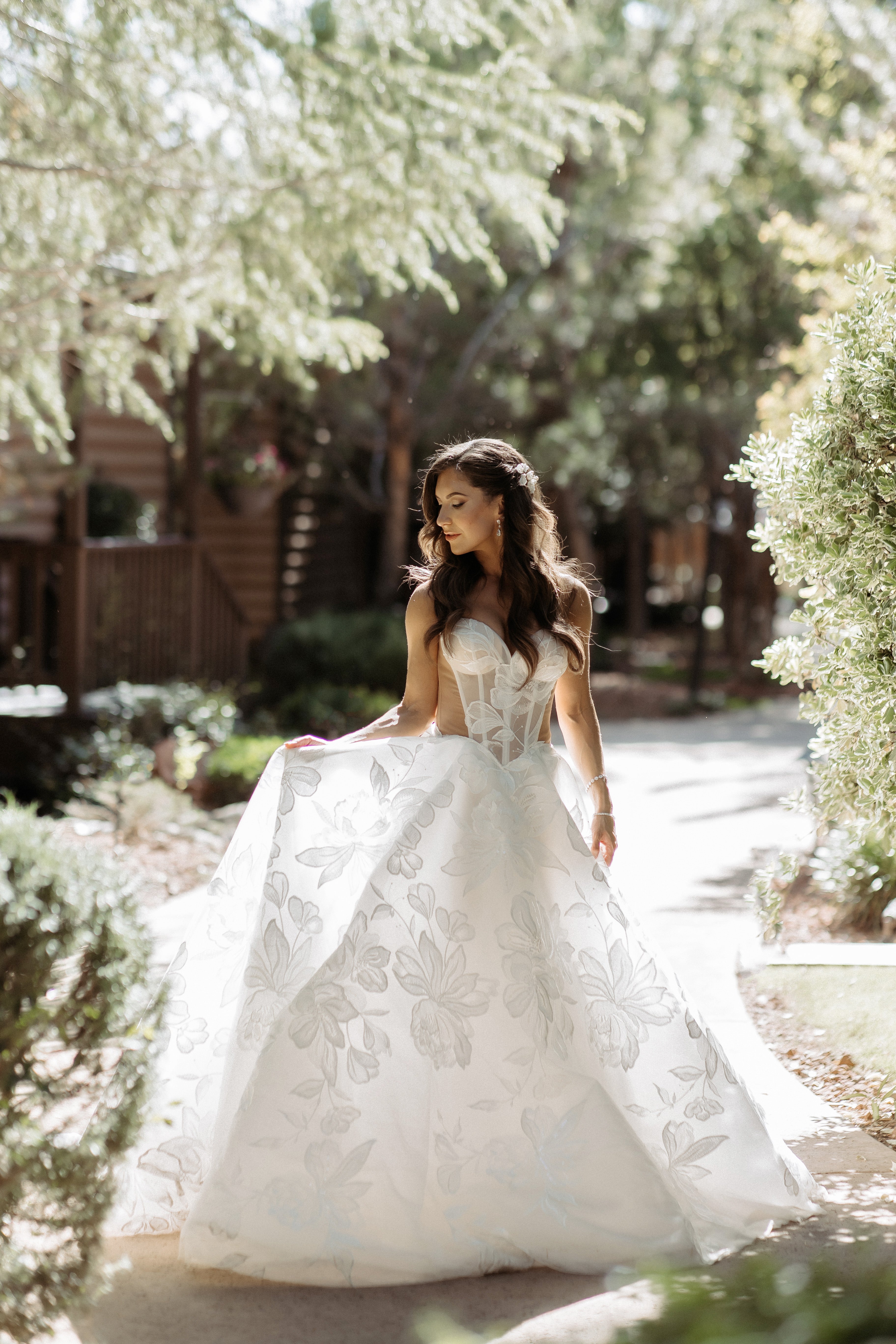 Woman in our Evelyn wedding dress standing in a garden setting