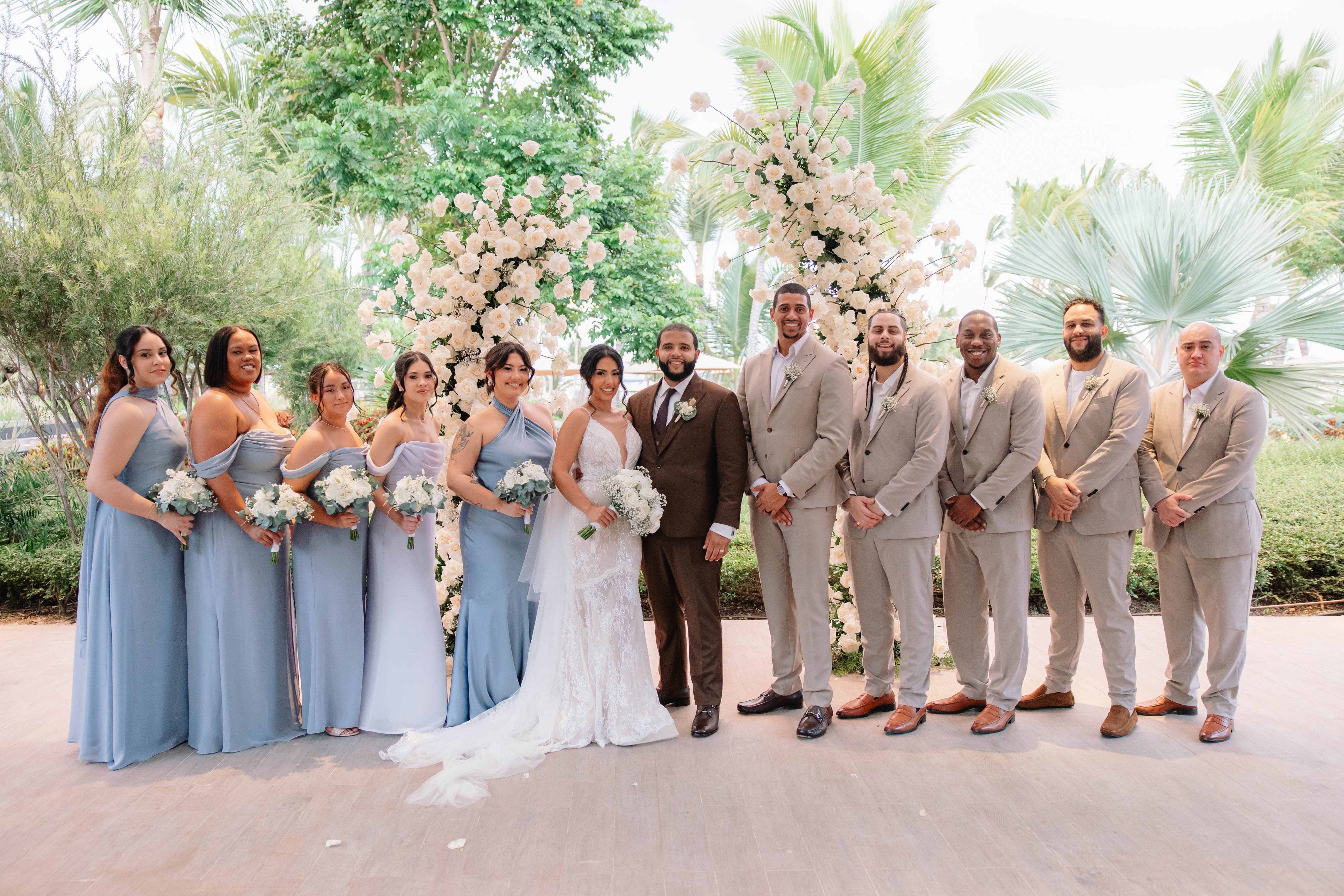 Wedding party posing outdoors with floral decorations