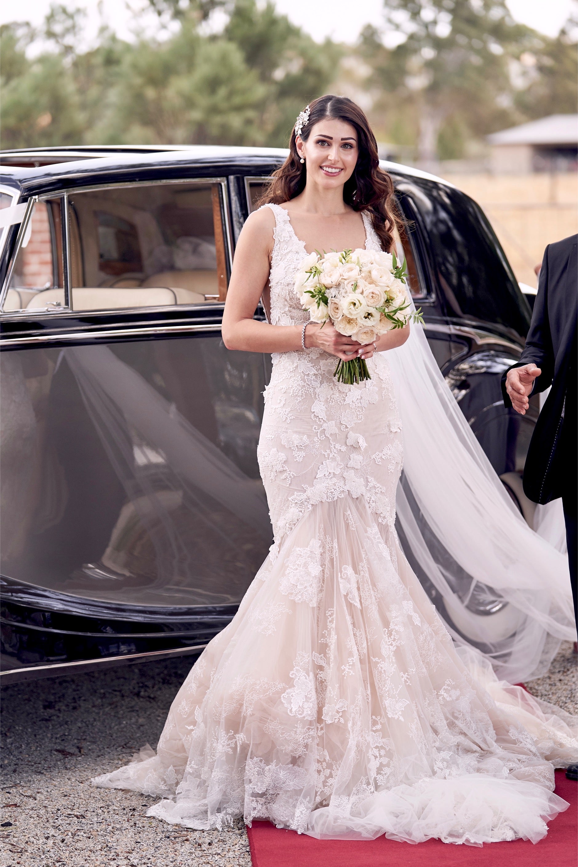 GL Bride Nadia wearing our GALA 1001 in front of a vintage car and red carpet