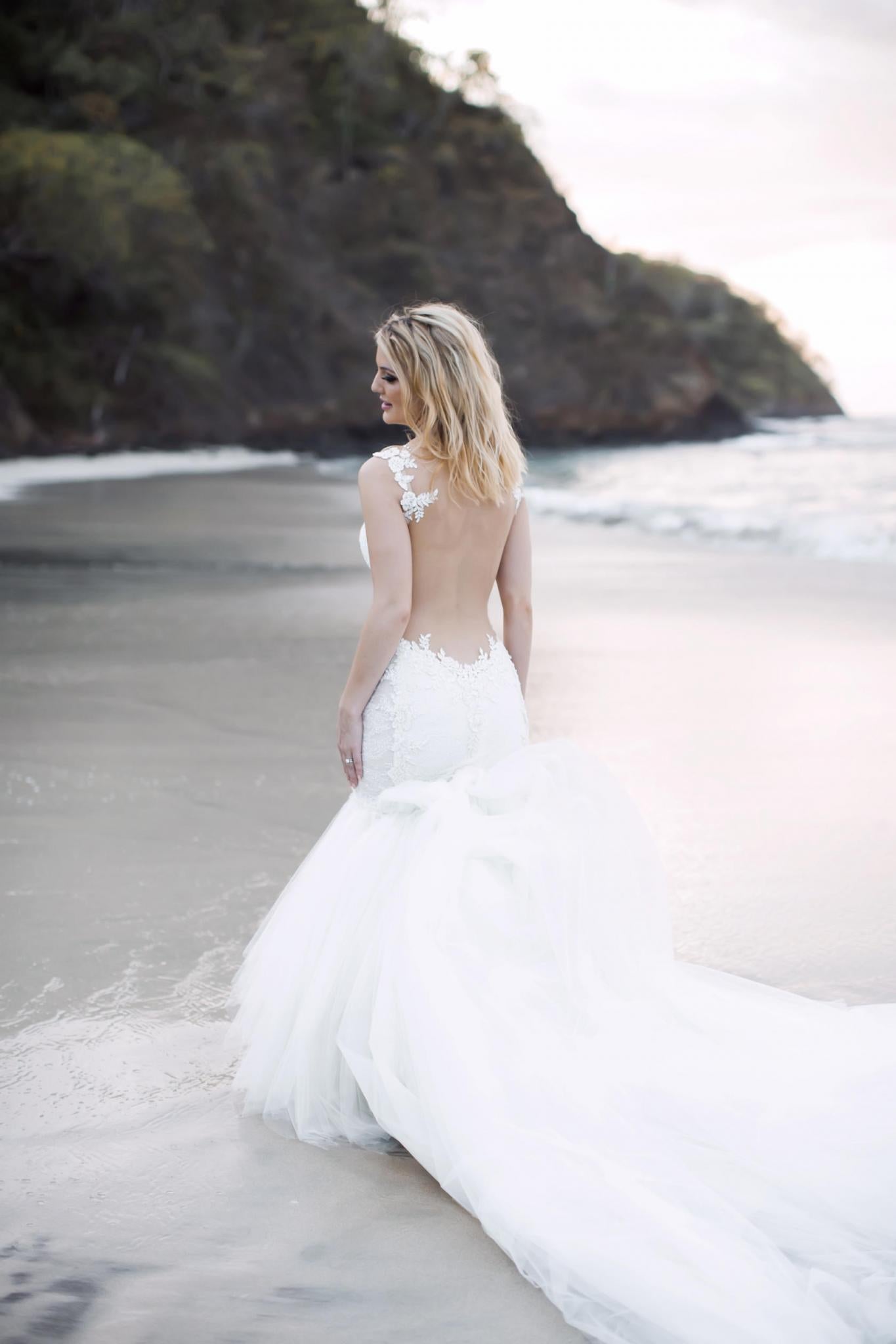 GL Bride Allie wearing our Loretta gown walking on the beach