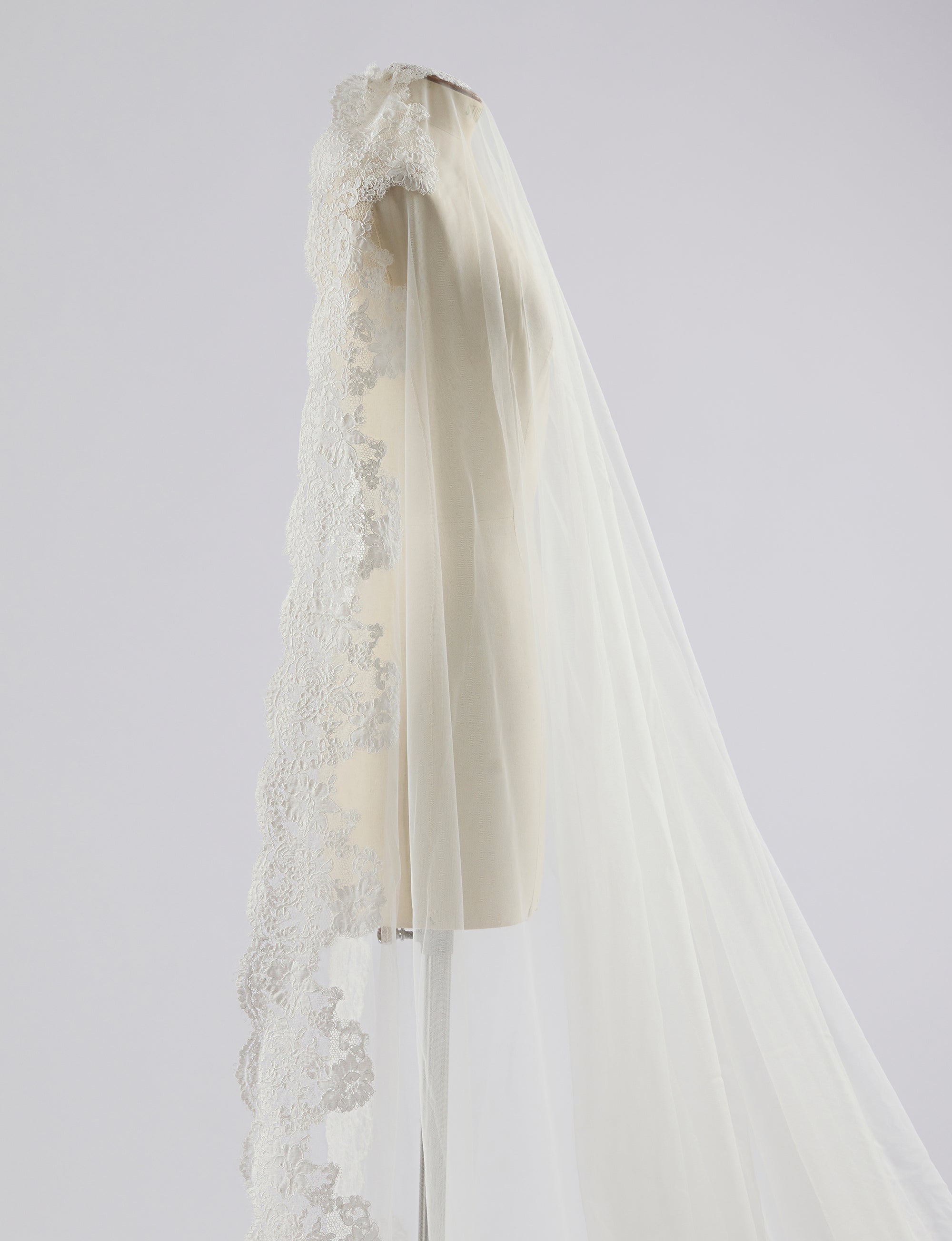 White wedding veil with lace details on a light gray background