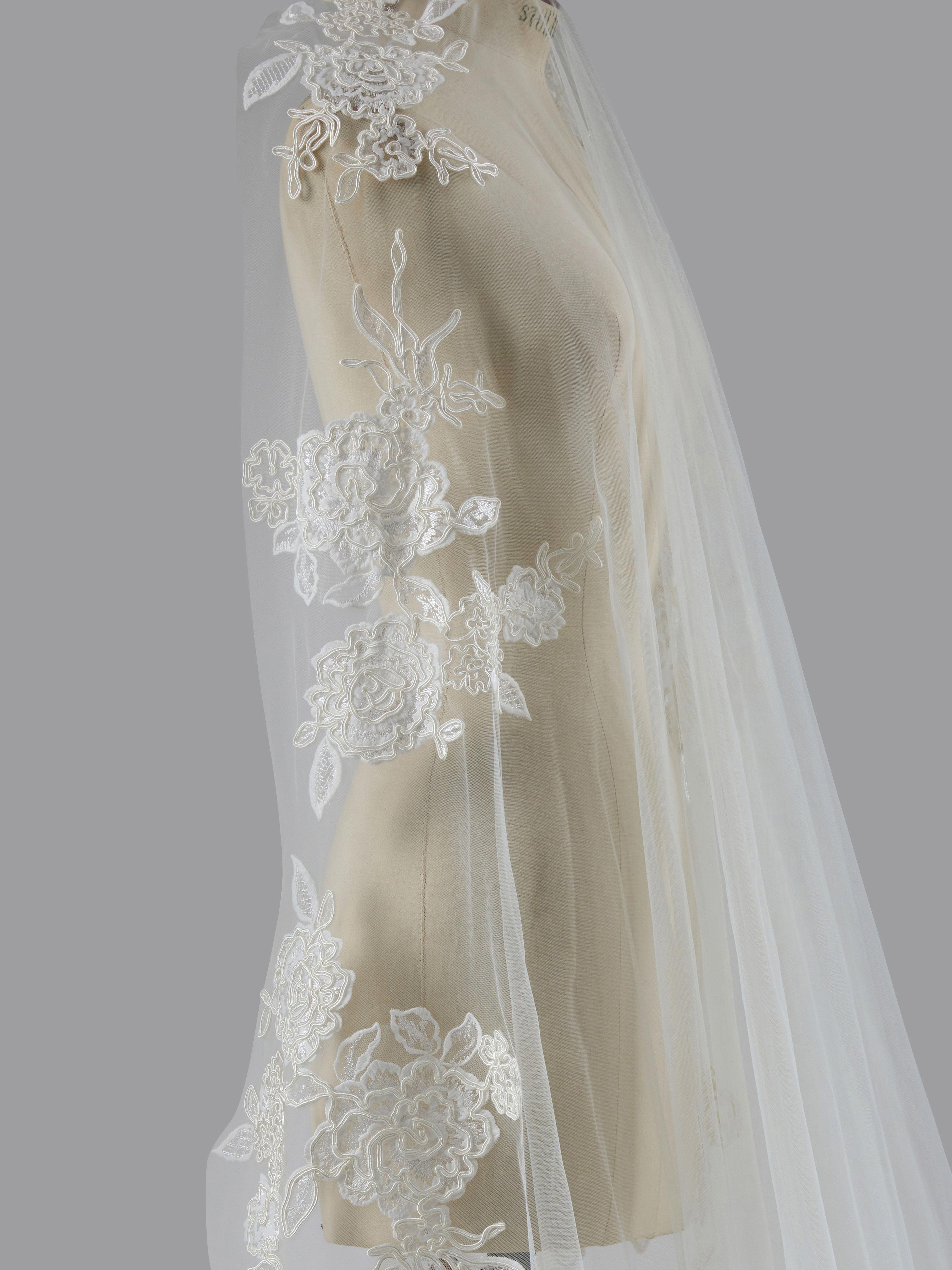 White lace veil on a mannequin against a gray background