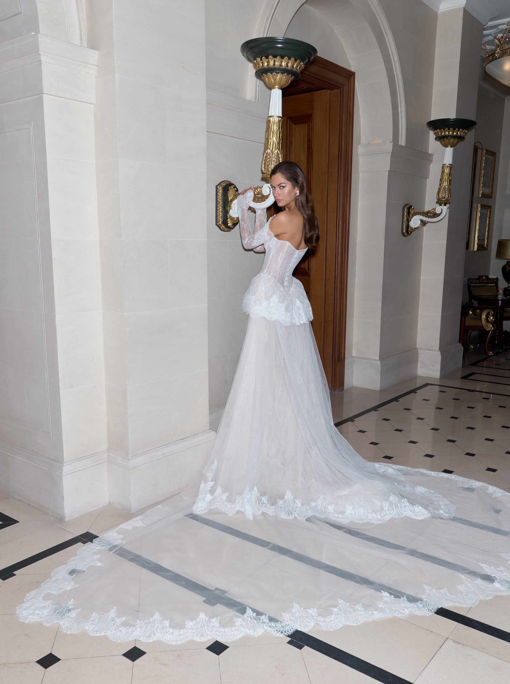 Woman in a white wedding dress standing in an elegant interior setting