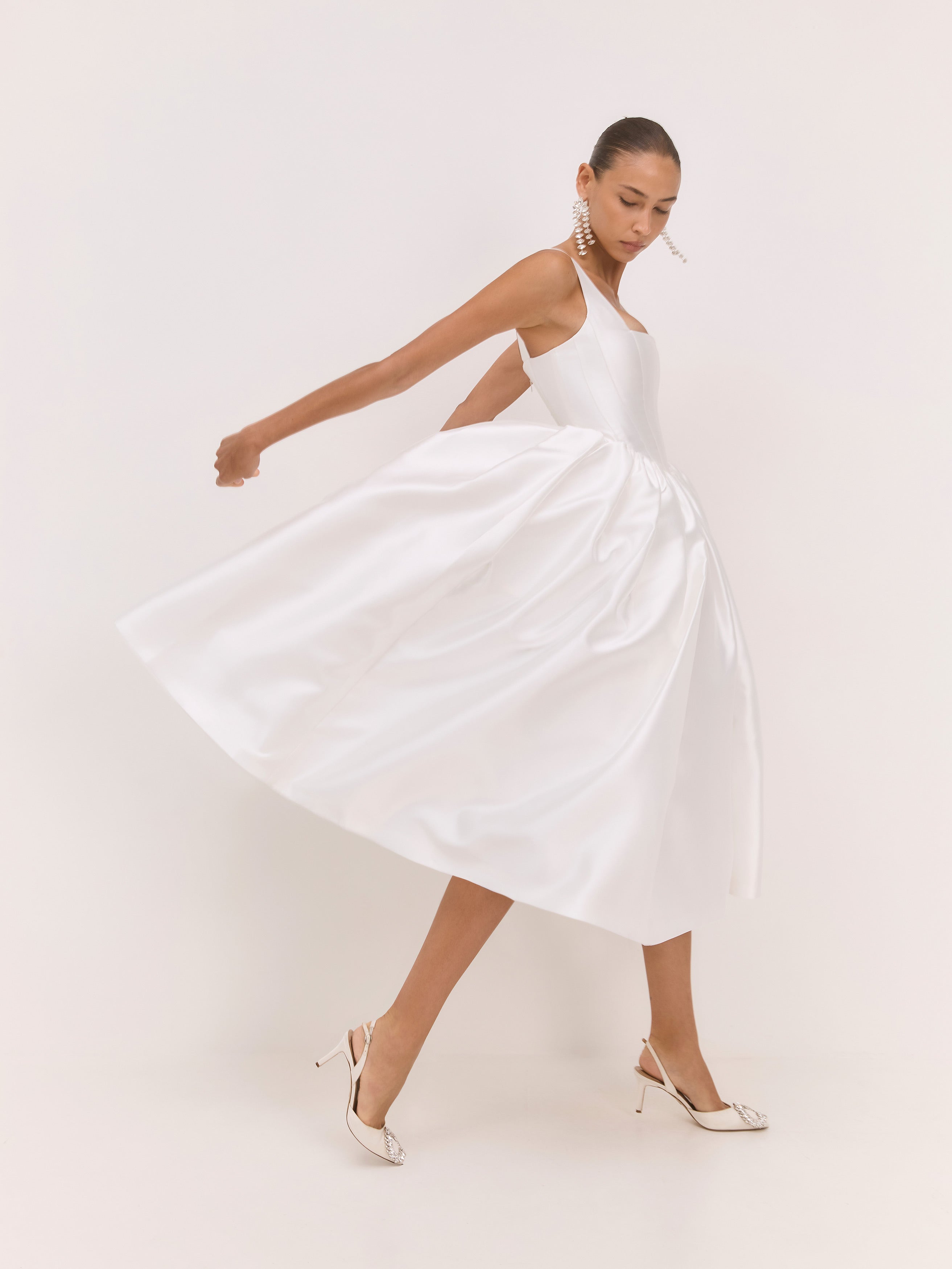 Woman wearing a white dress on a plain background