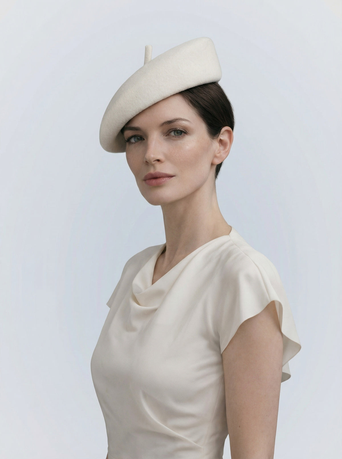 Woman wearing a white beret against a light gray background