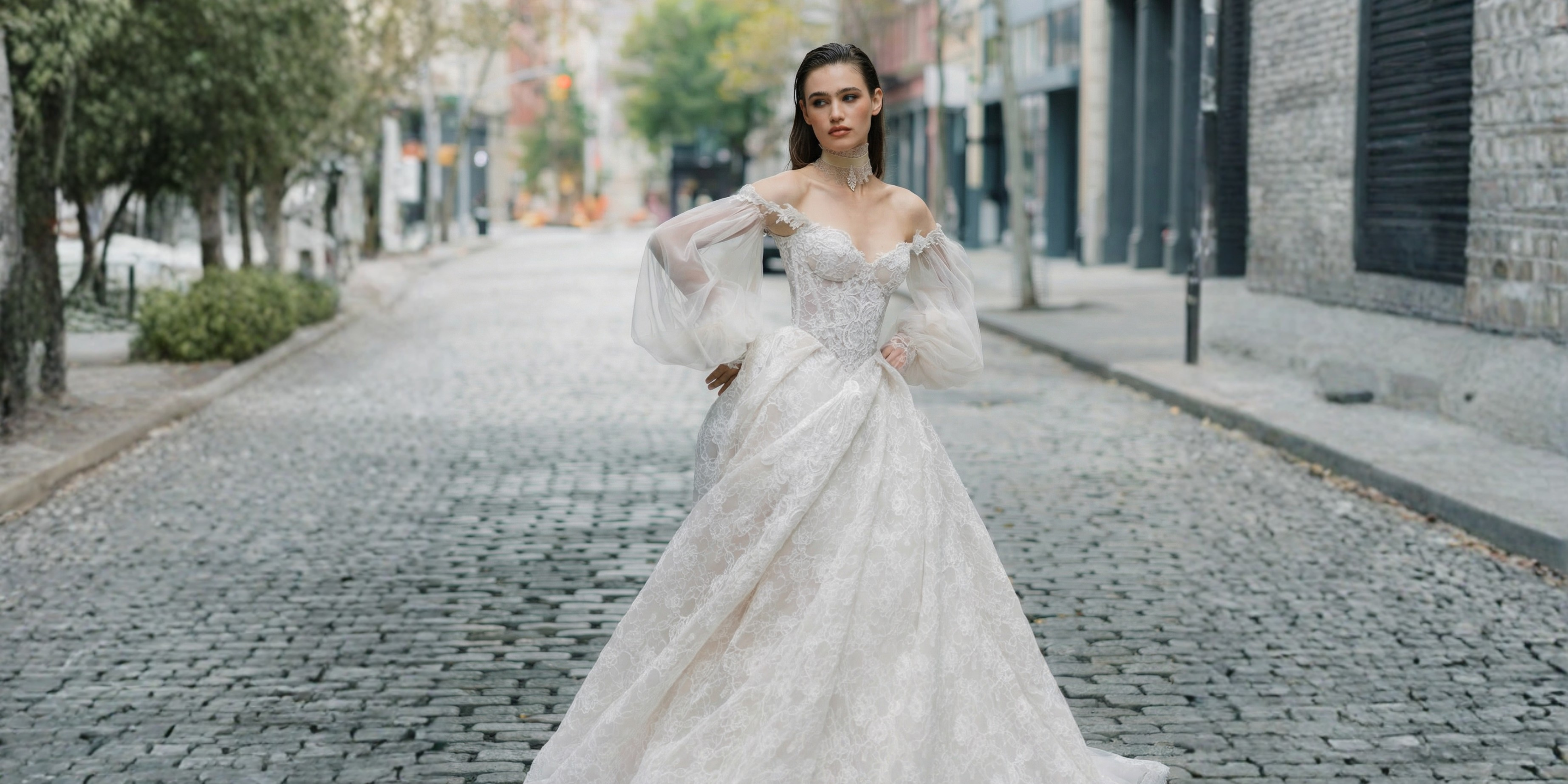 Woman in a white wedding dress walking on a city street.