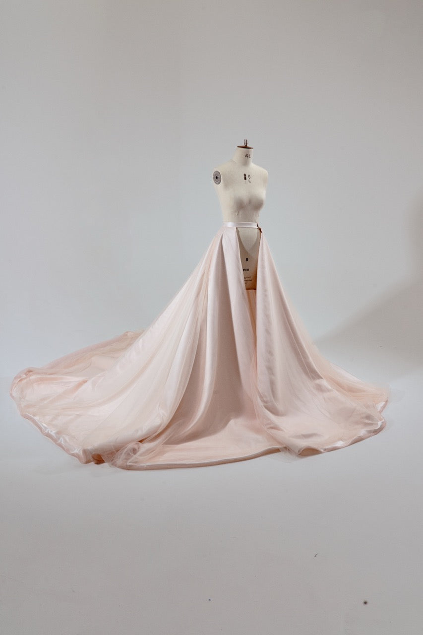 Pink dress on a mannequin against a plain background