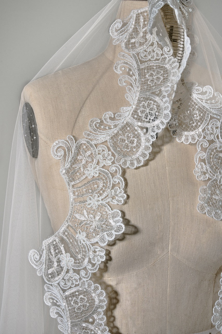 Elegant lace veil on a mannequin against a neutral background