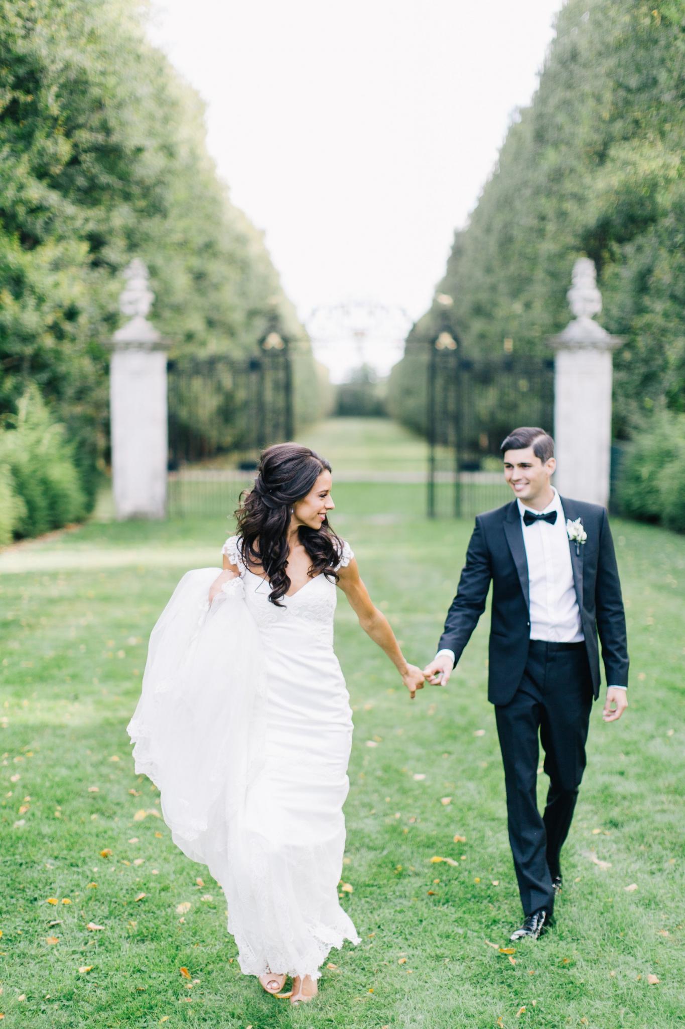 GL Bride Jennifer in our Fiona gown walking through the field with her groom 
