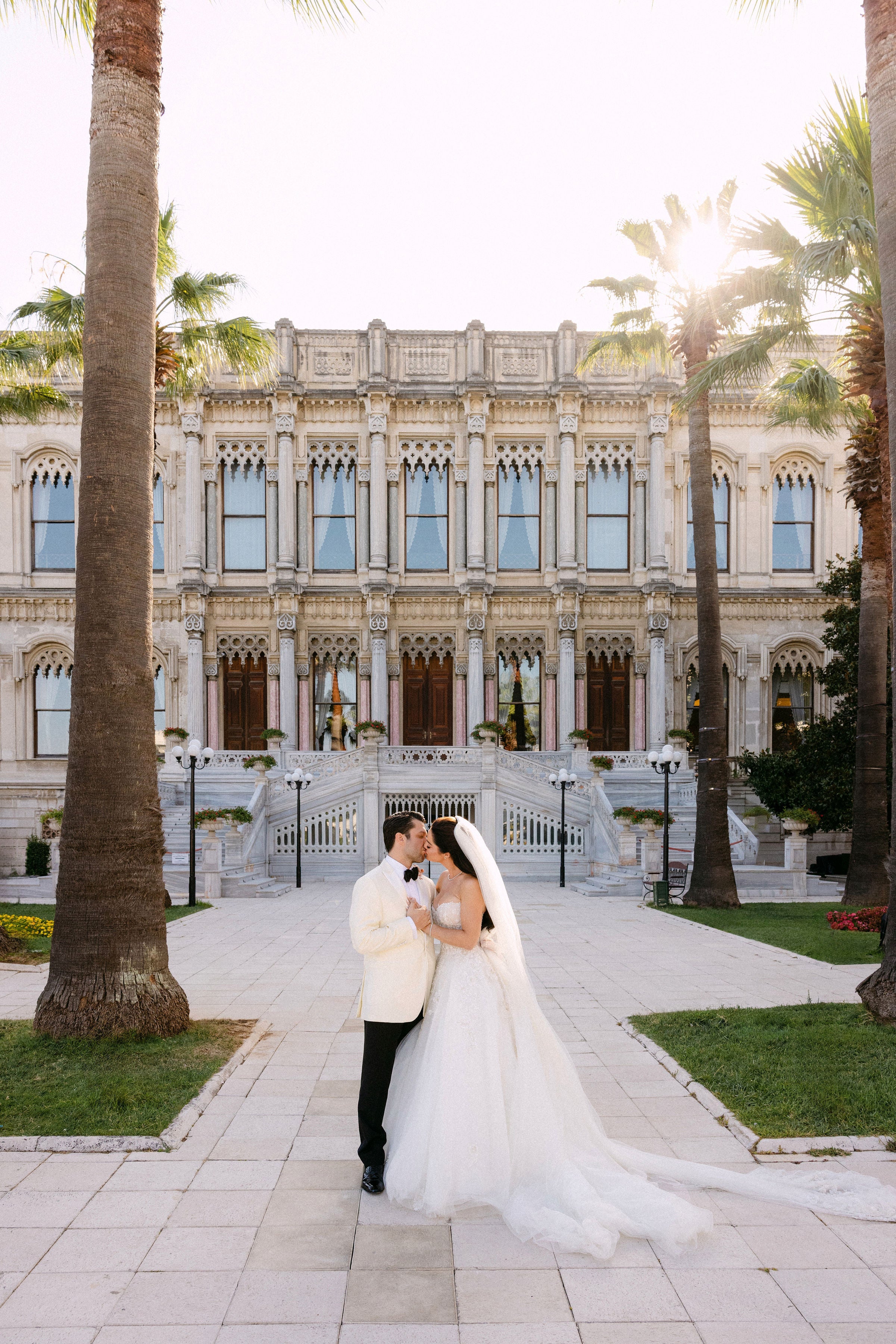 Wedding couple in front of an elegant building with palm trees