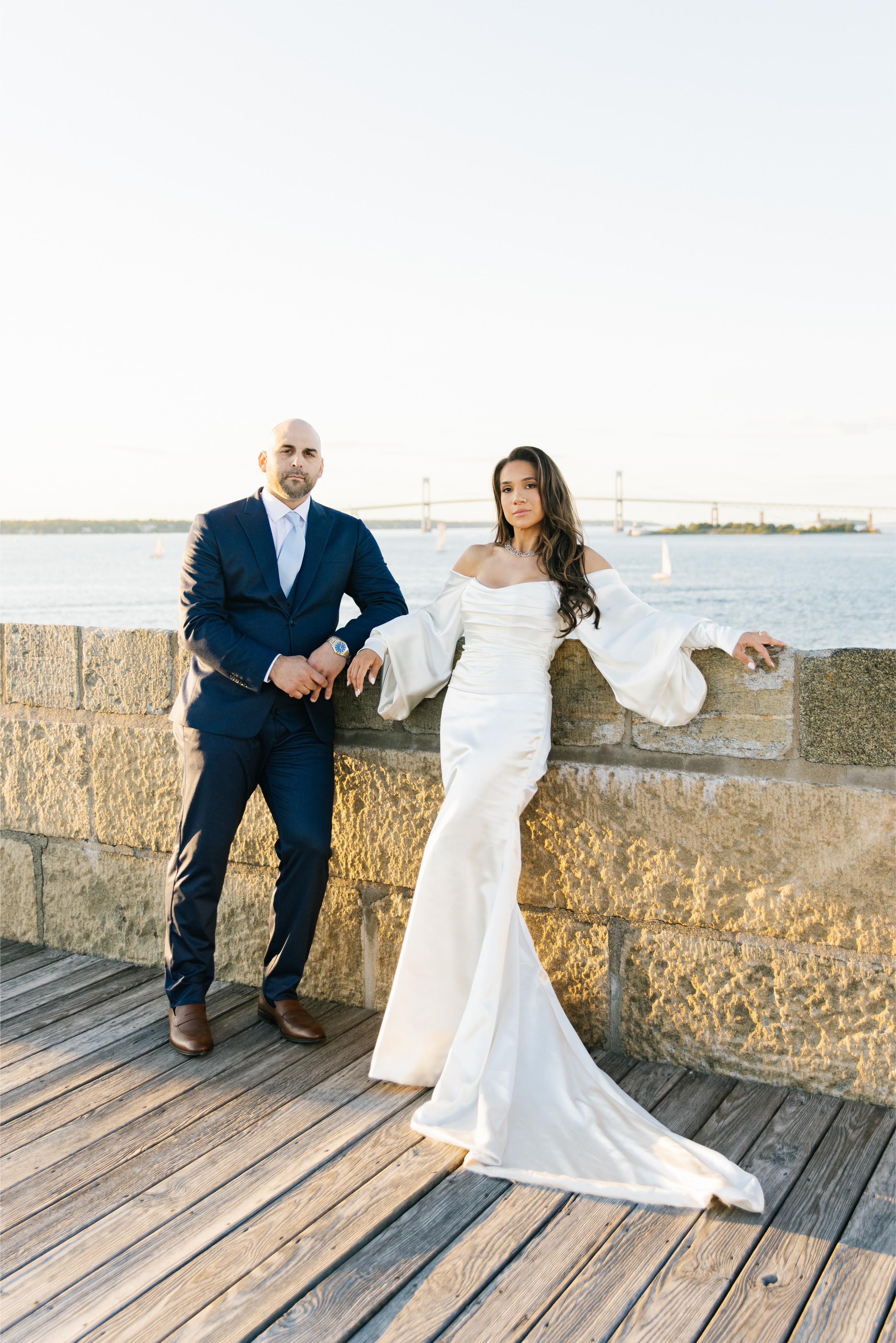 GL Bride Alexandra in Galia Lahav's Alona with her husband, standing on a wooden deck by a waterfront