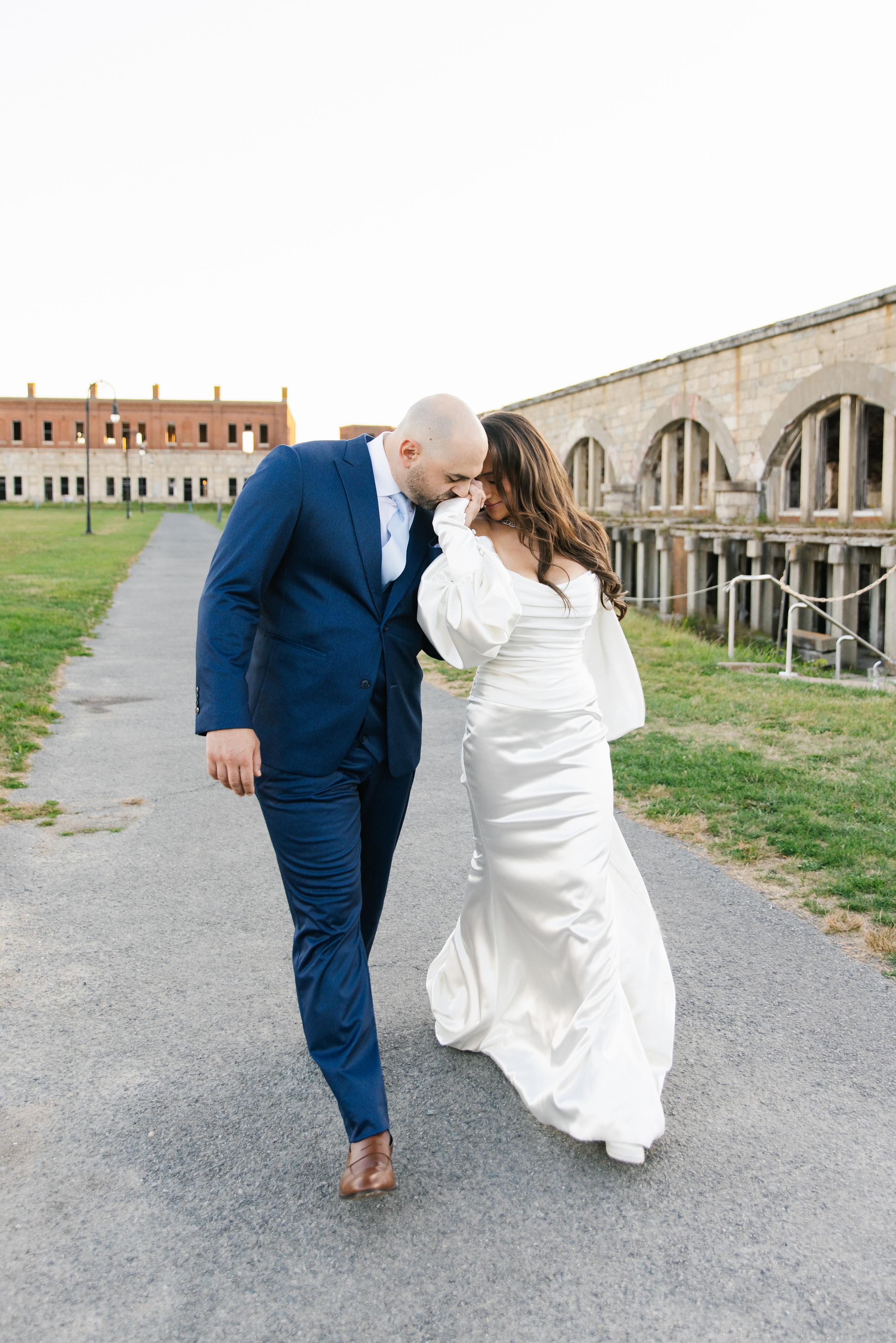 GL Bride Alexandra in Galia Lahav's Alona  walking together on a path with historical building in the backgrounds 
