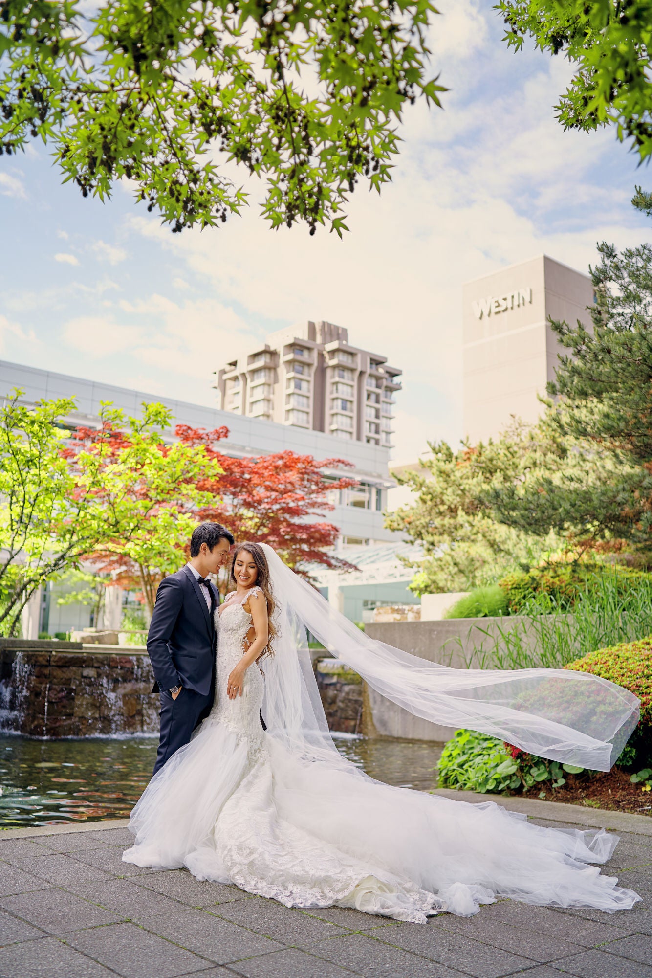 GL Bride Anita wearing our Ms. Elle gown standing with her husband 