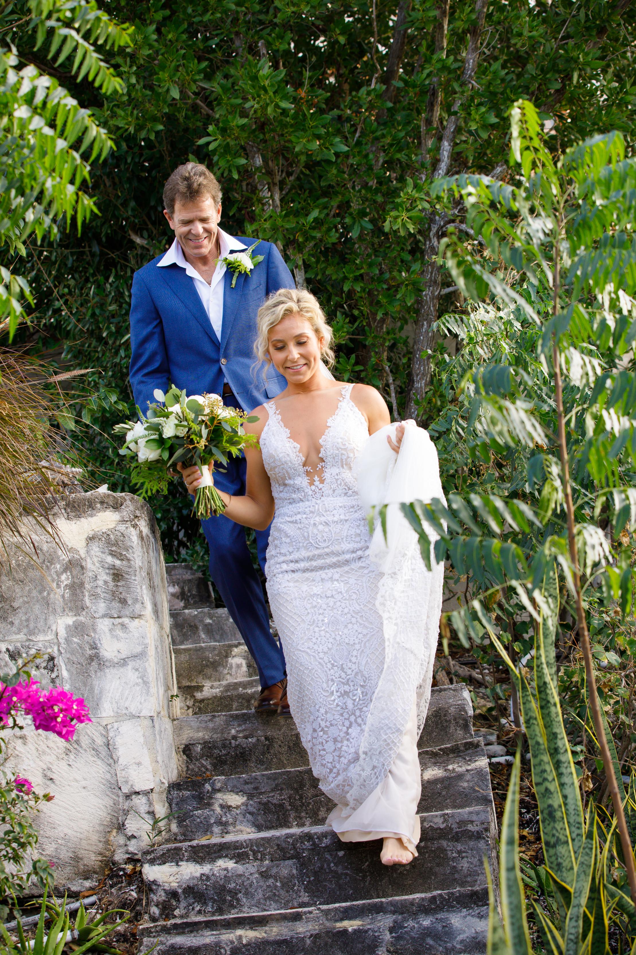 GL Bride Carly our GALA 708 and her  walking down stone steps in a lush, tropical setting.
