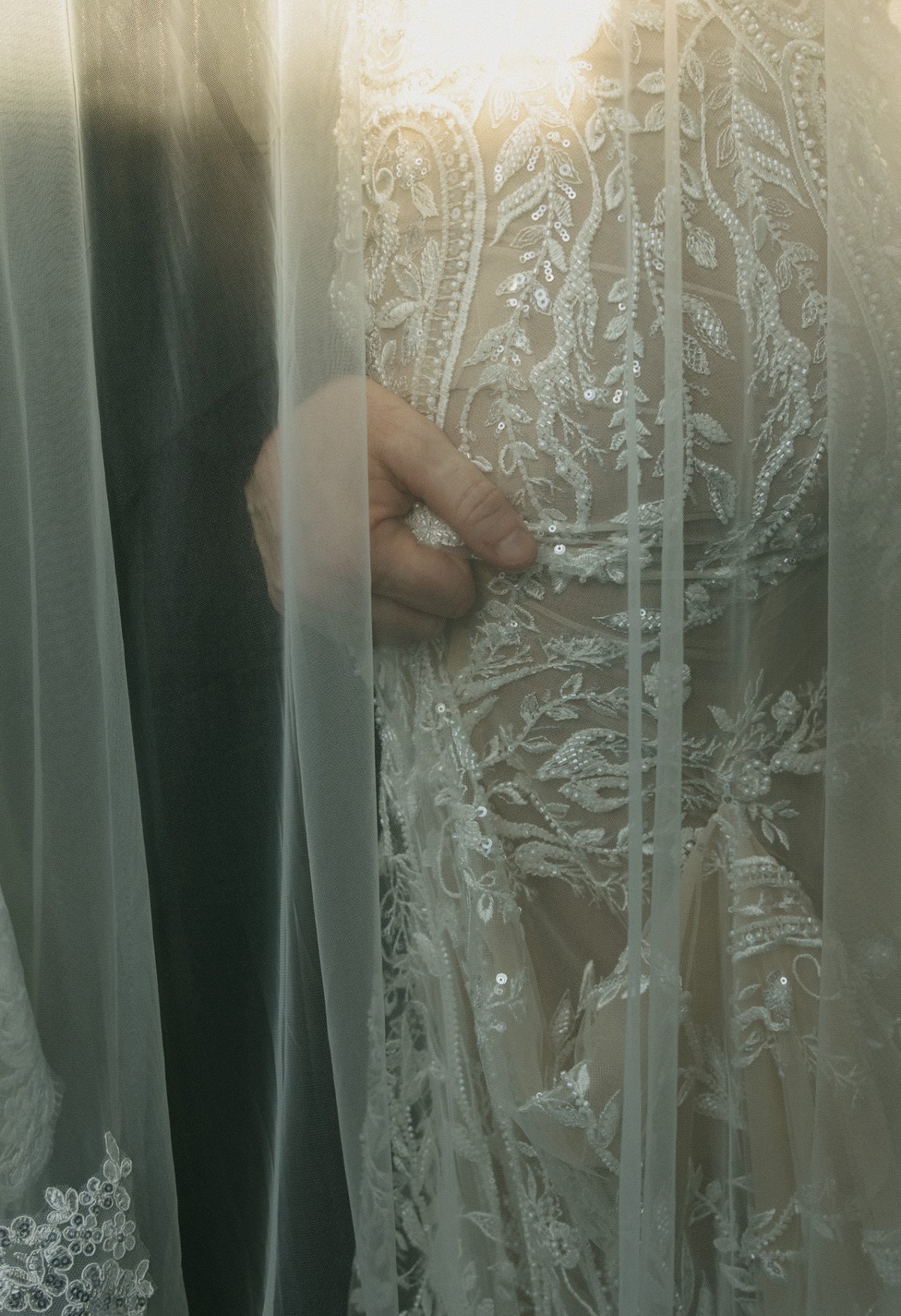 Close-up of a person wearing a white lace dress with intricate detailing.