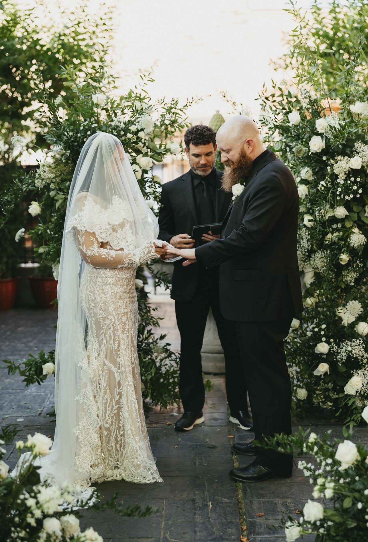 Wedding ceremony with a couple and a officiant in a decorated outdoor setting.