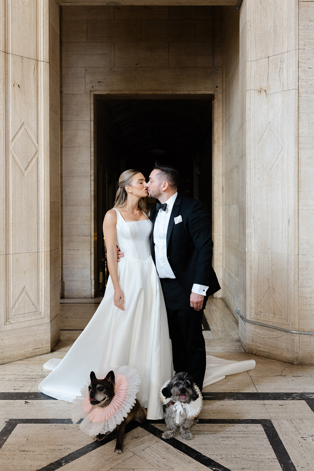 GL Bride Eliza in our Dove gown with her husband and ttheir two dogs in a formal setting