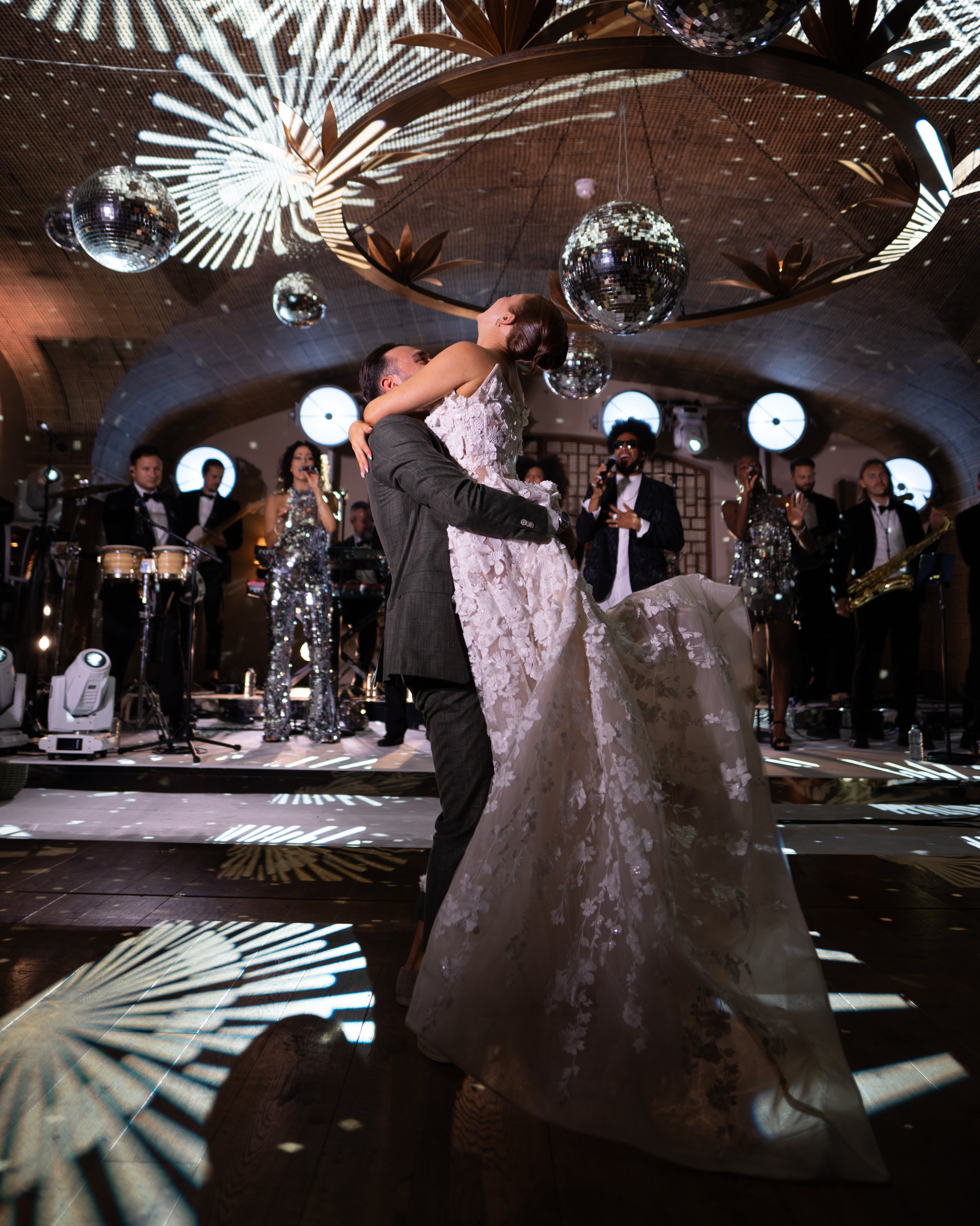 GL Bride Emily in our Rosemary and her husband dancing in a celebratory setting with band and disco balls