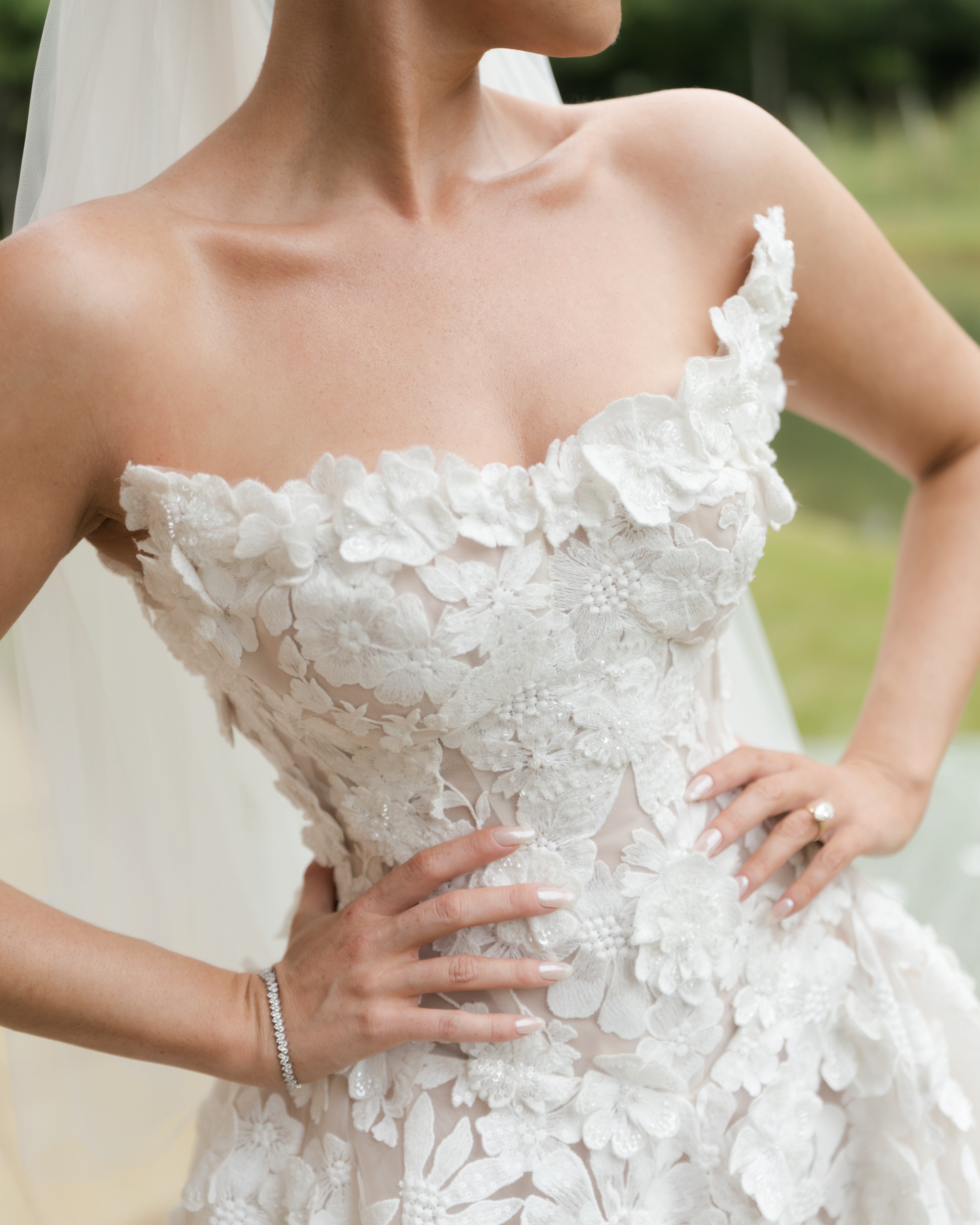 GL Bride Emily in our Rosemary gown with a blurred natural background