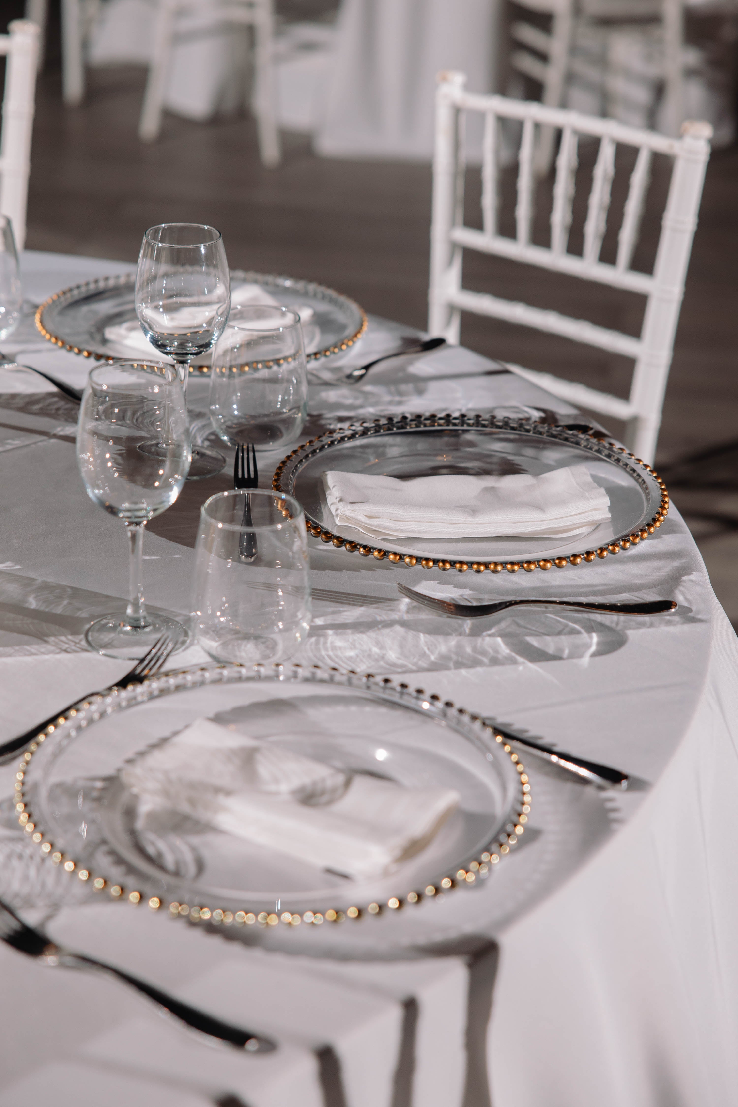 Elegant table setting with plates, glasses, and cutlery on a white tablecloth.
