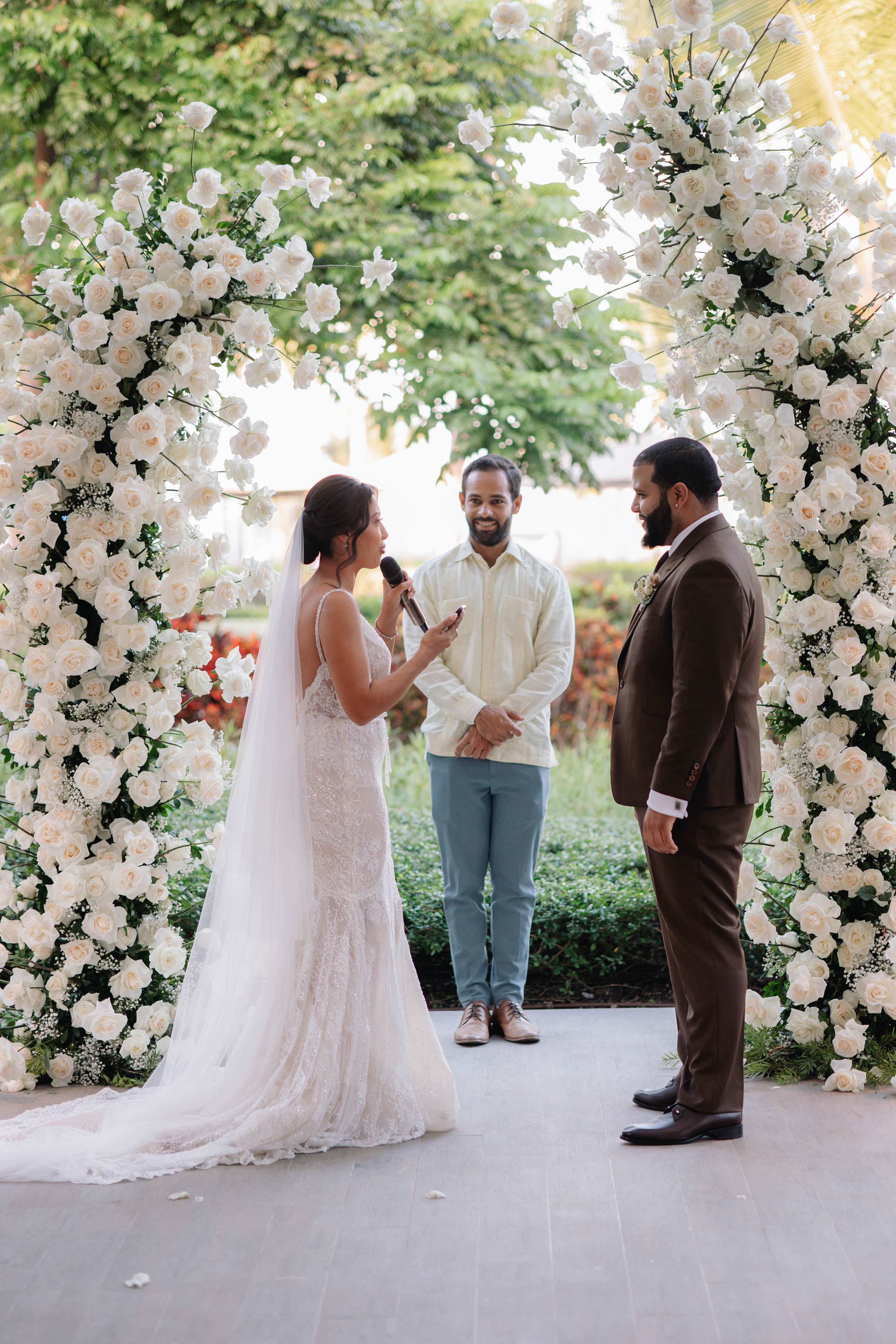 Wedding ceremony with a couple standing under a floral archway.
