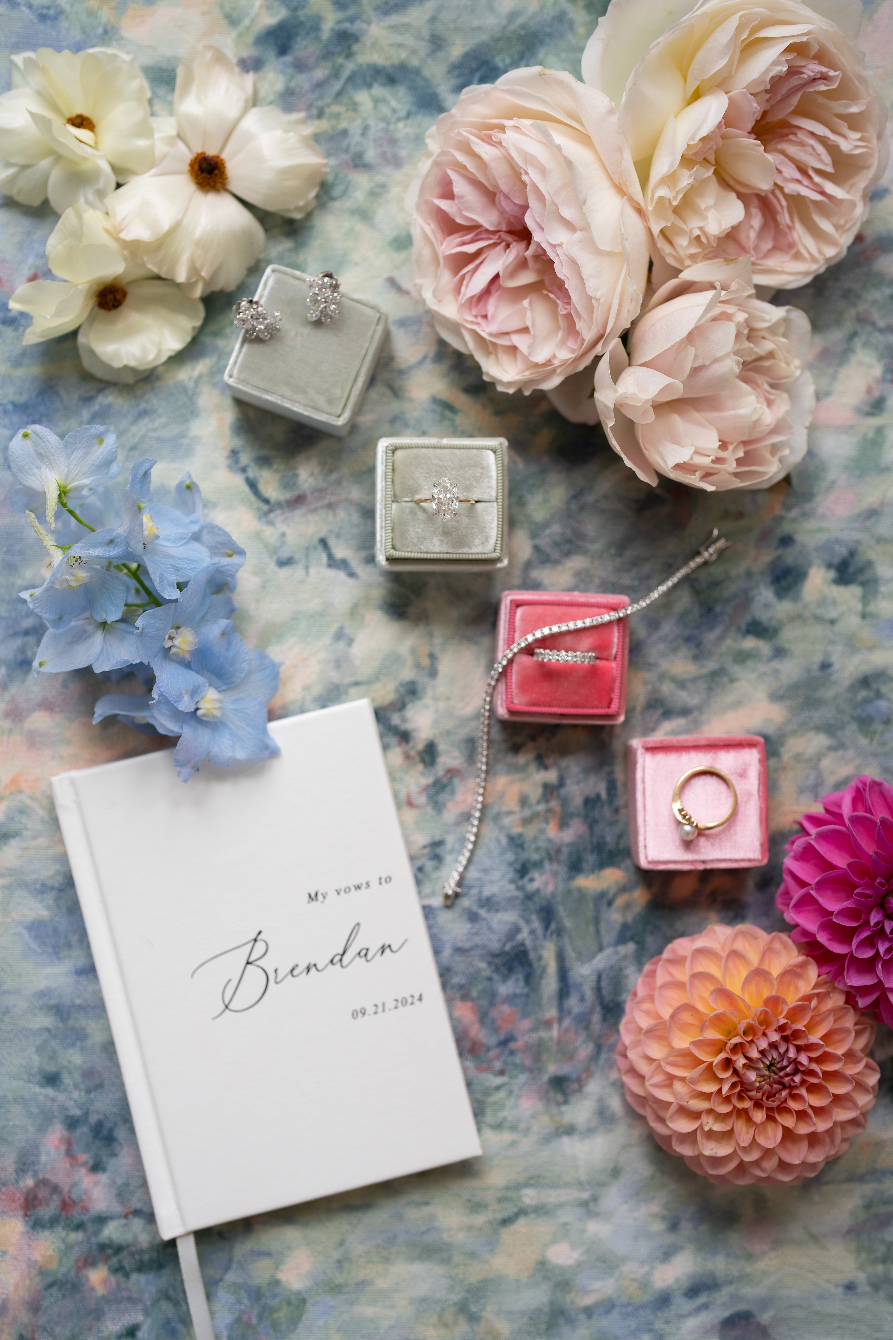 Engagement rings in boxes with flowers on a textured surface