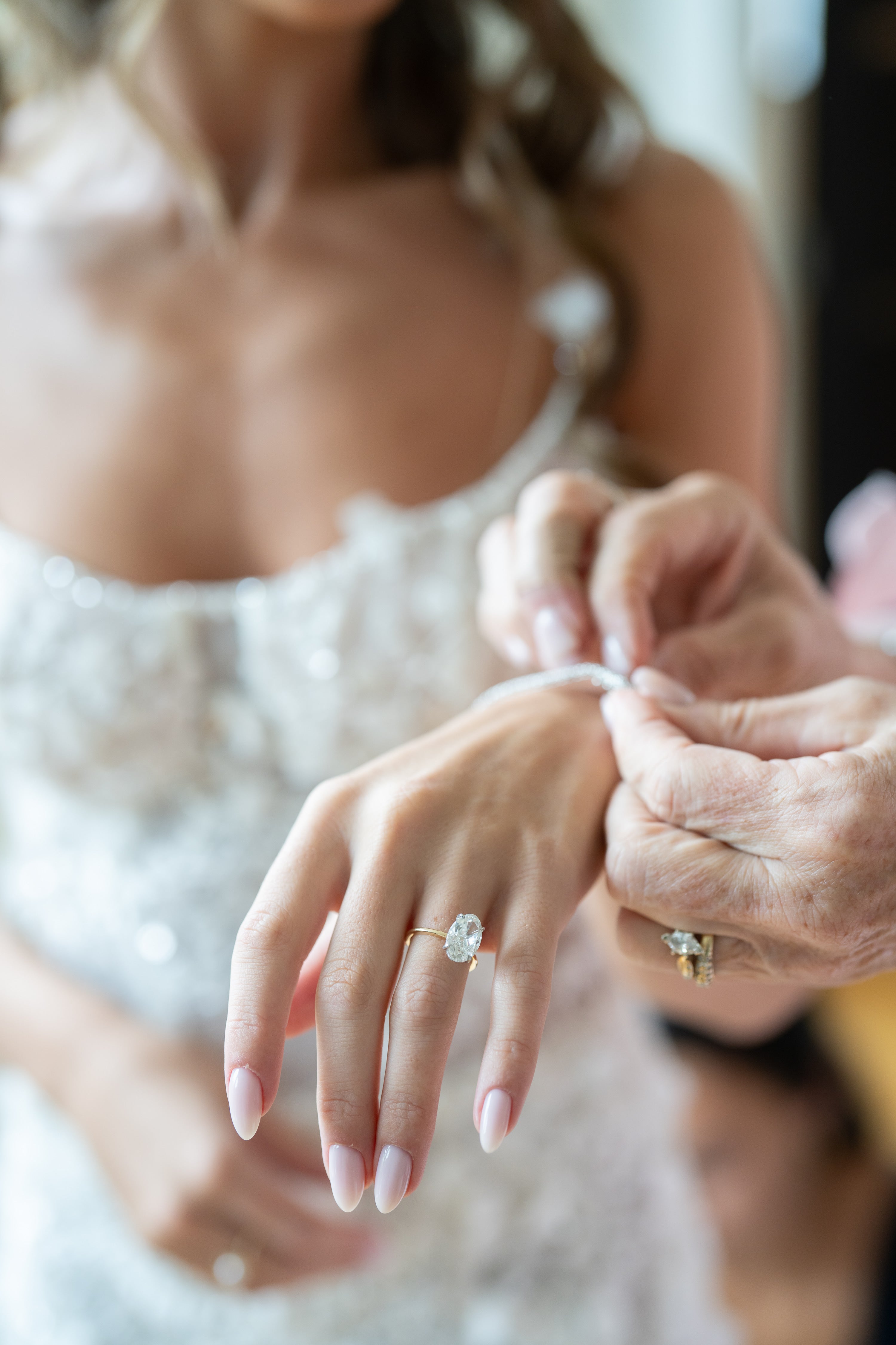 Close-up of a bride and groom's hands with wedding rings.