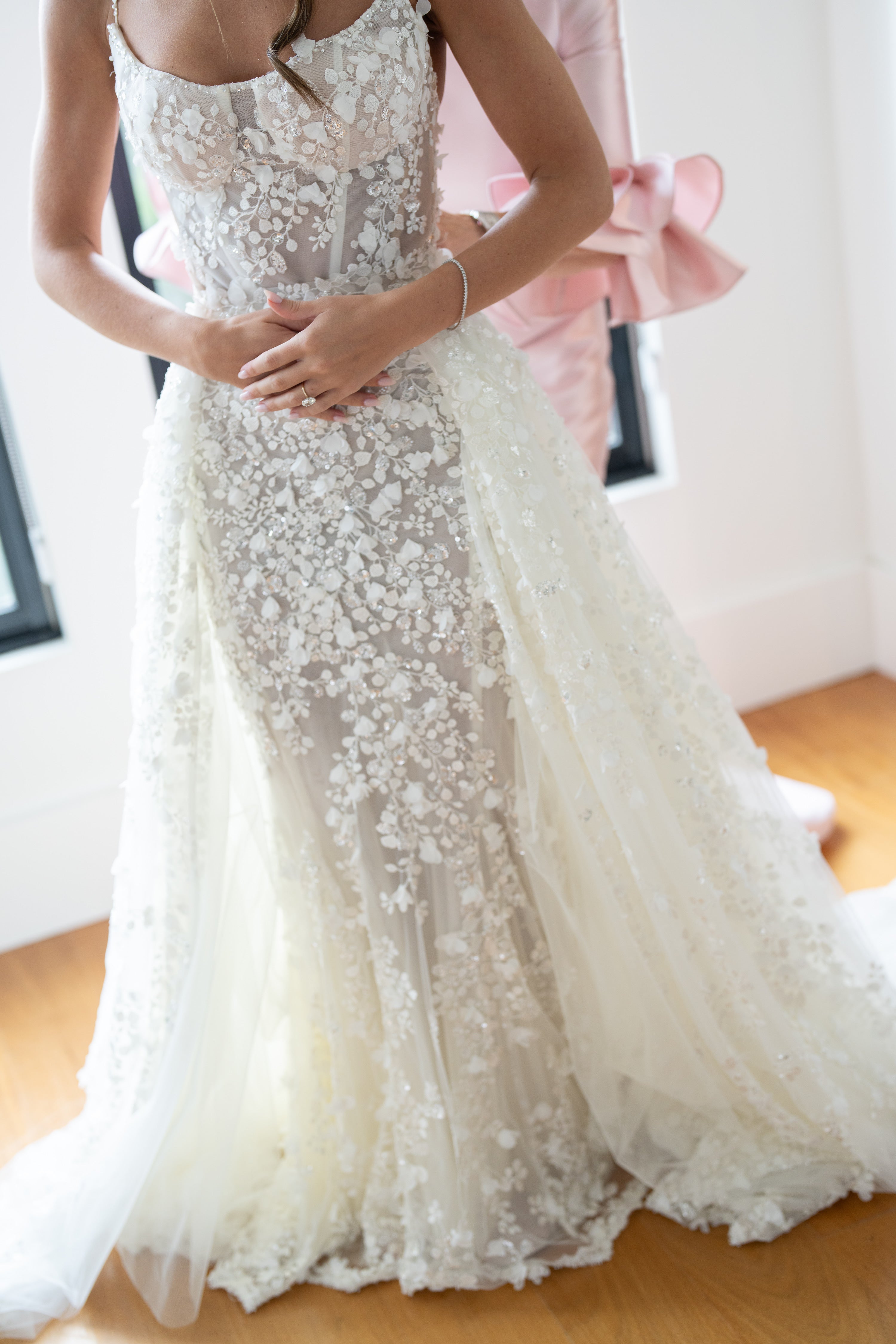 White lace wedding dress on a wooden floor with a blurred background