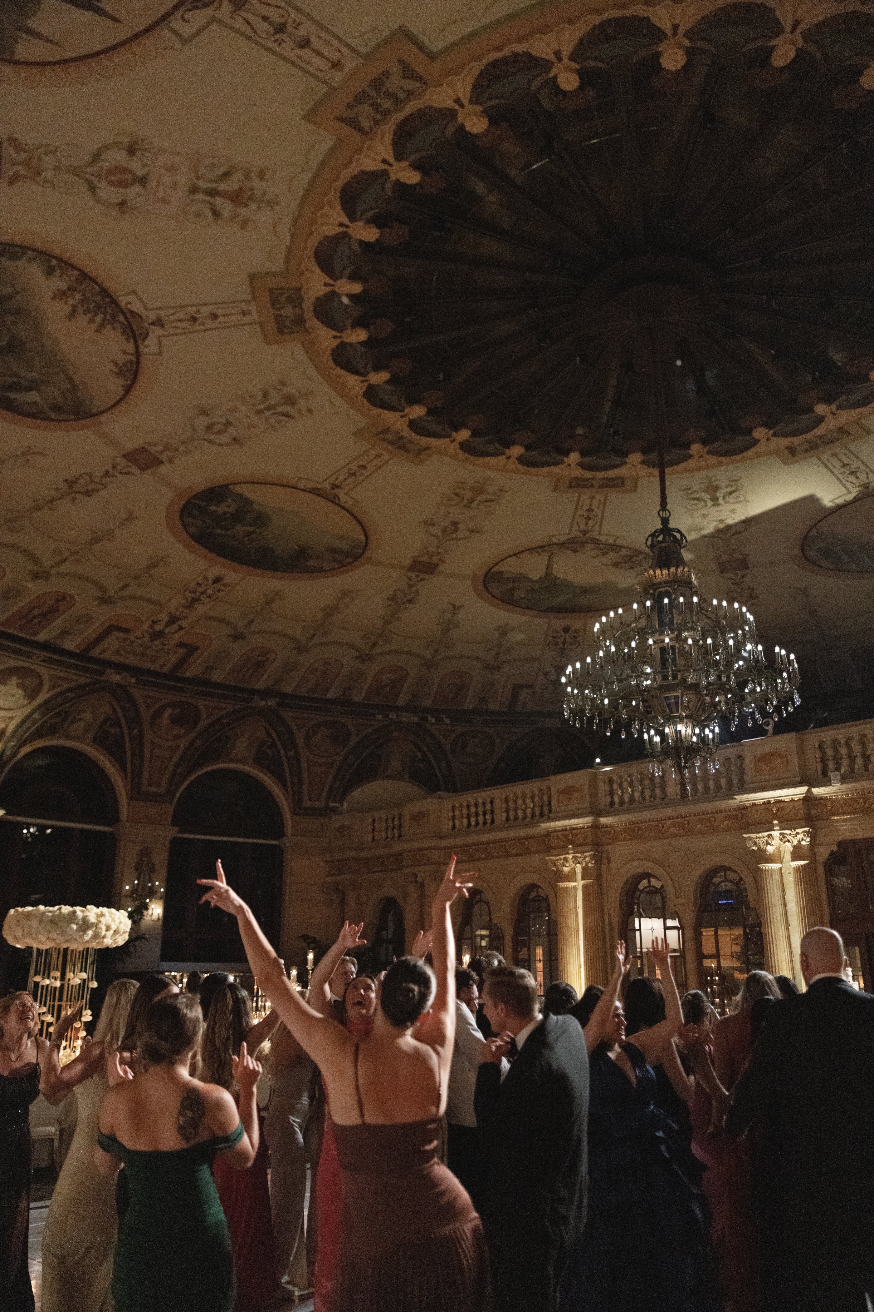 Dance floor with people celebrating in a grand ballroom with ornate ceiling.