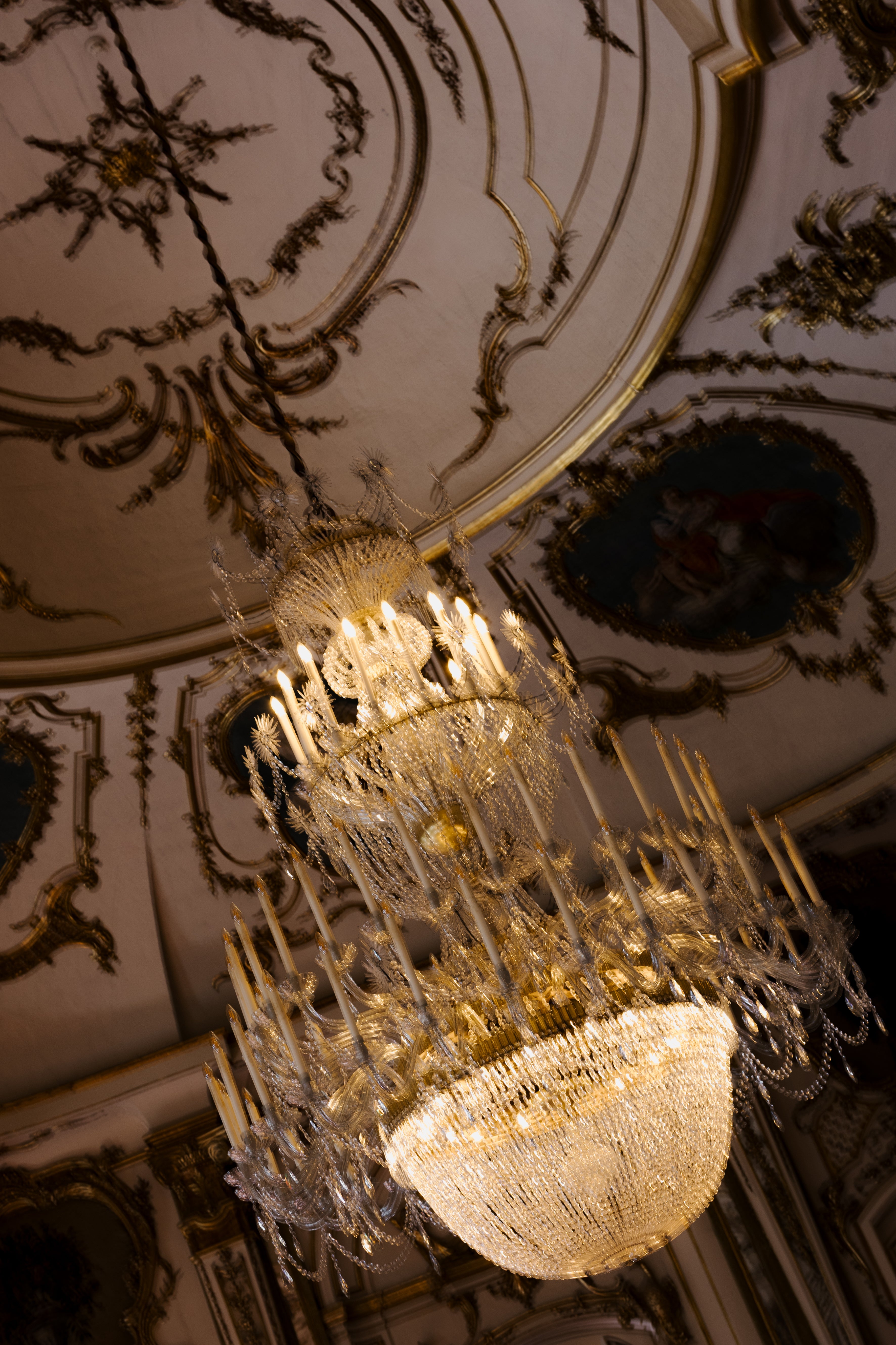 Decorative chandelier hanging from a ornate ceiling