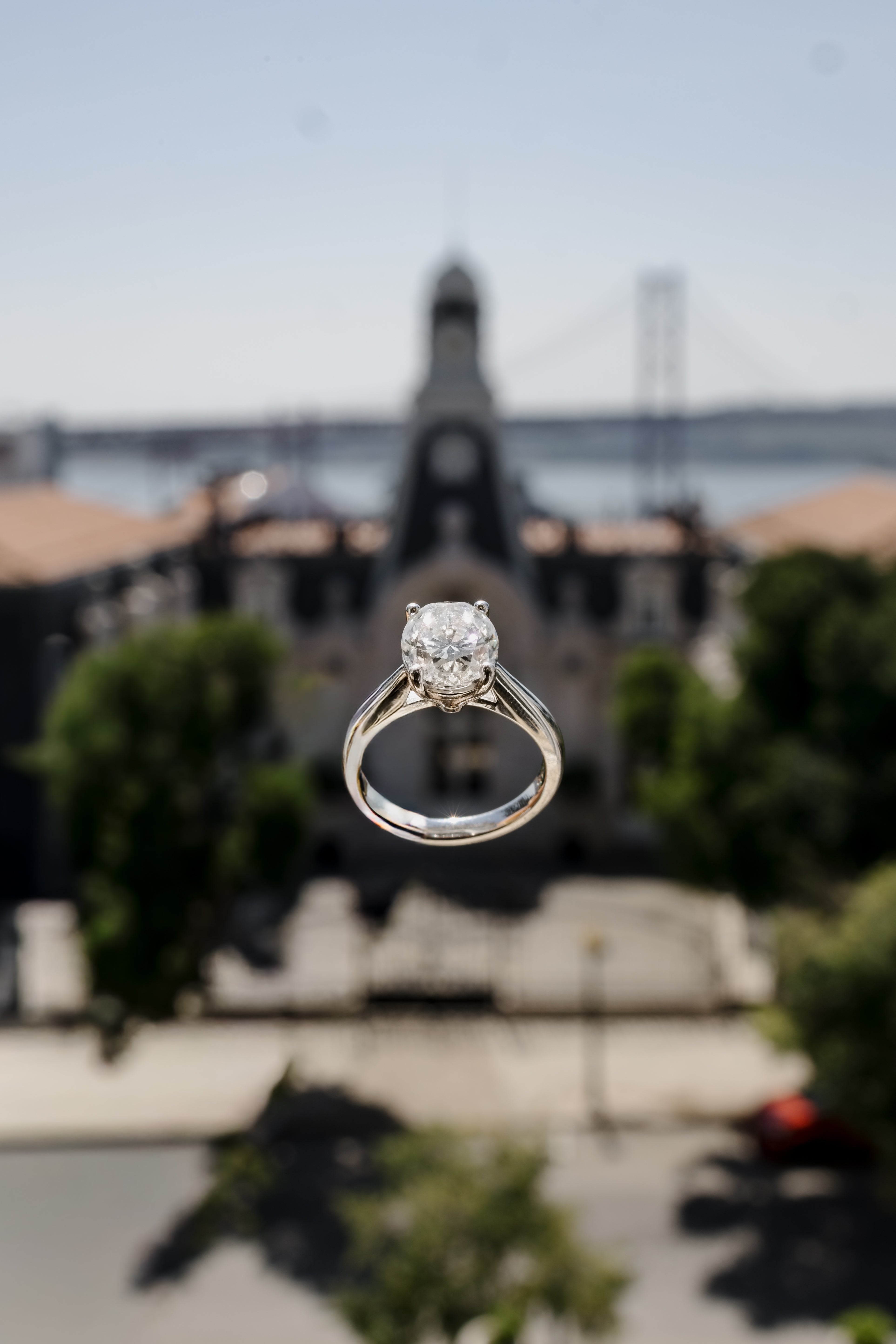 Diamond ring with a blurred background of a building and trees