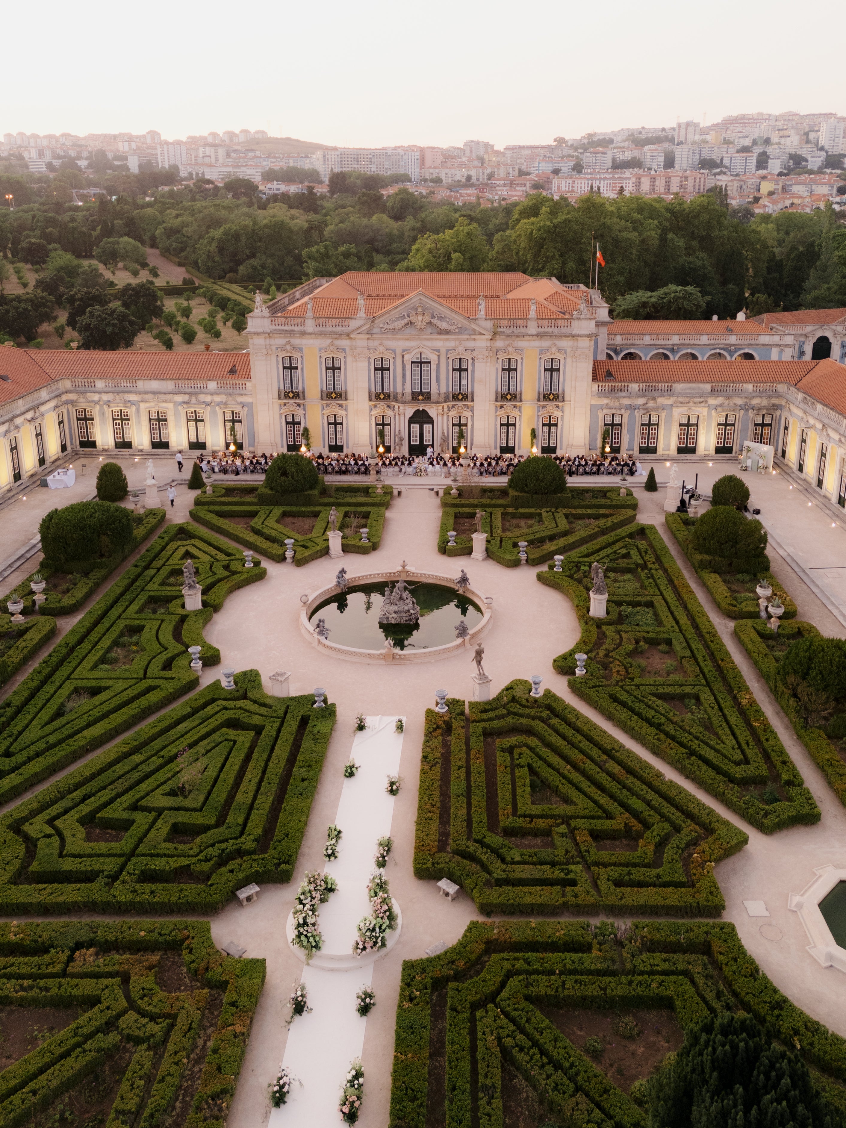 A grand building with a well-manicured garden in the foreground