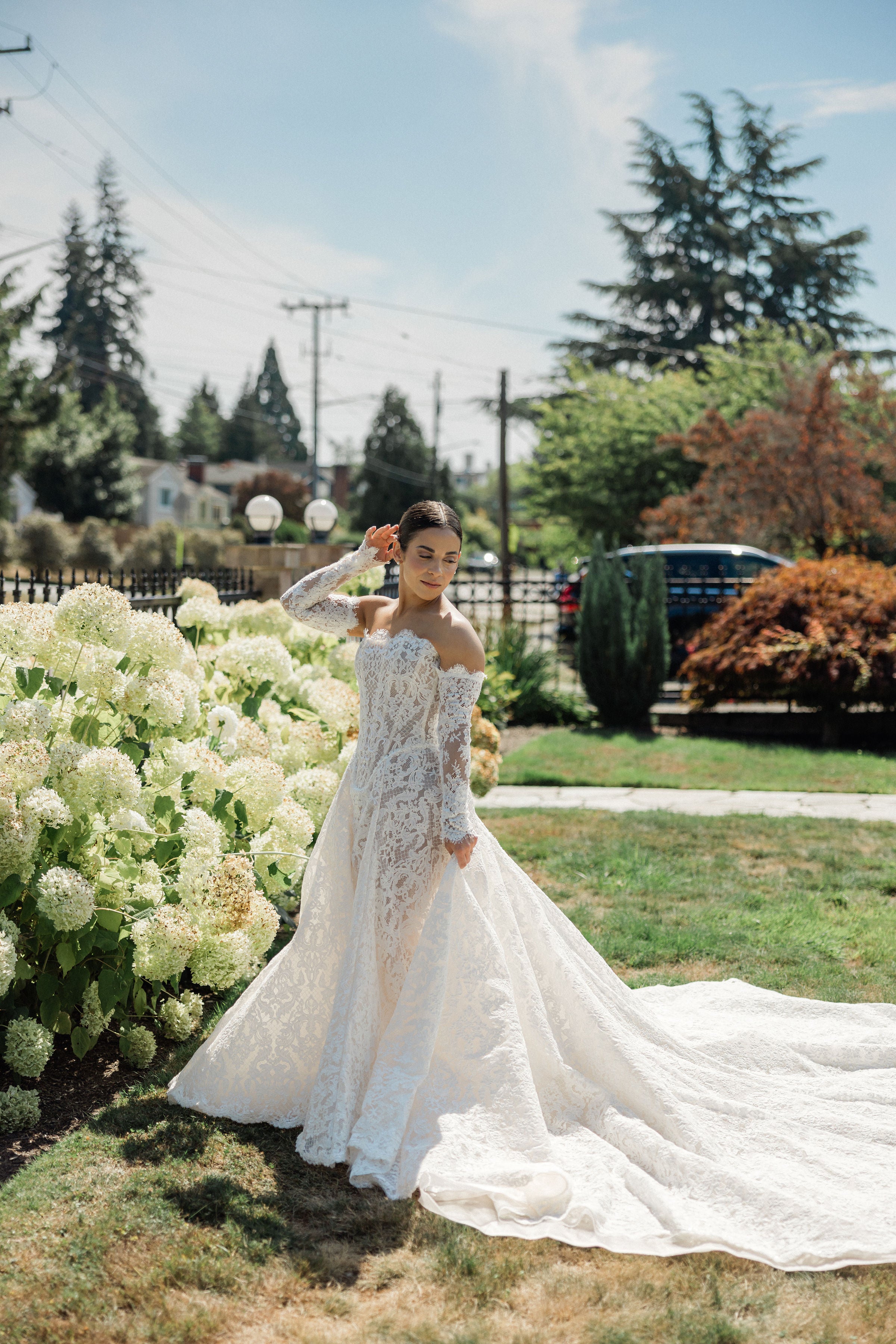 GL Bride Megan wearing Galia Lahav Splendid standing in a garden with flowers and trees in the background.