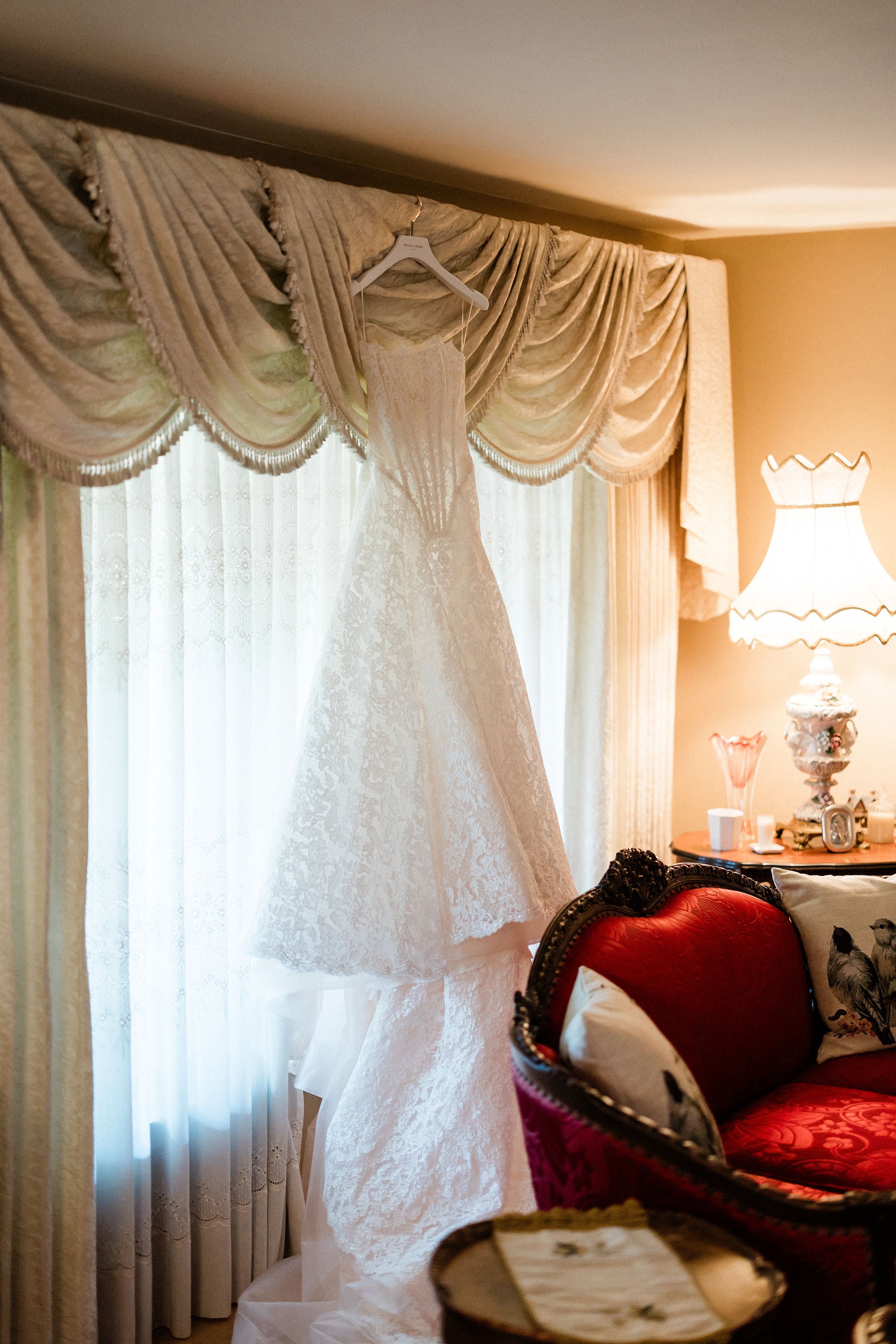 Galia Lahav Splendid hanging in a room with curtains and a lamp.