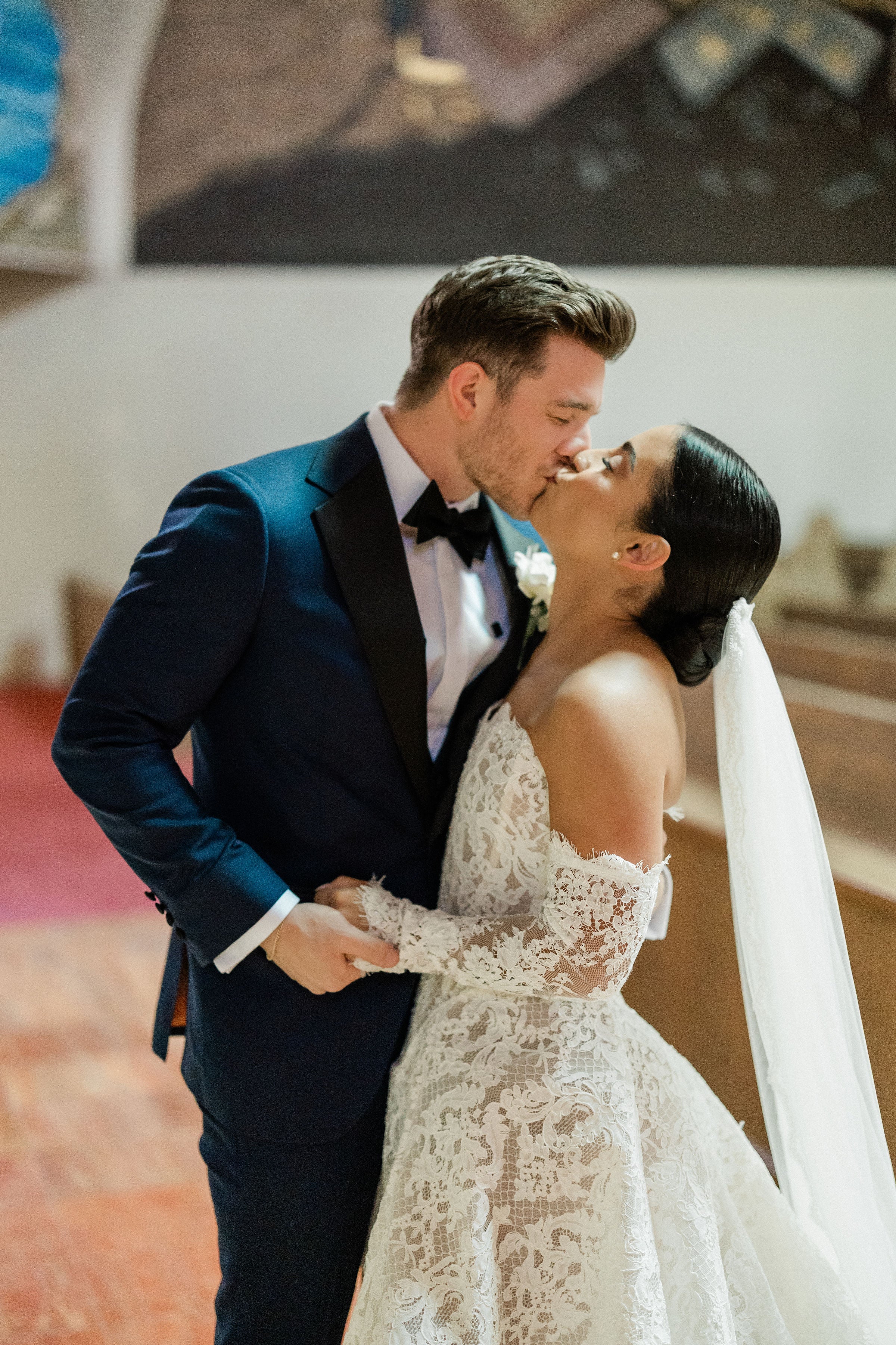 GL Megan wearing Galia Lahav Splendid, with her husband kissing in an indoor setting.