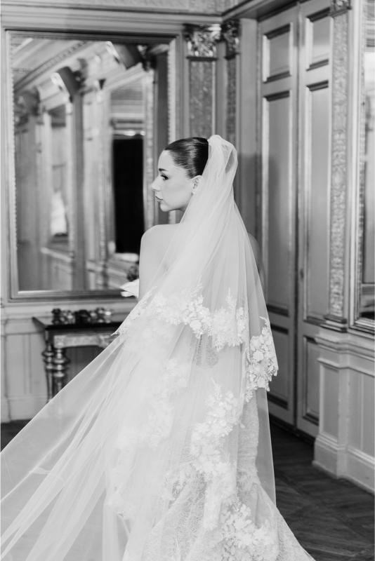 GL Bride Rebecca in the Scarlett wedding dress with a long veil in a room with mirrors.
