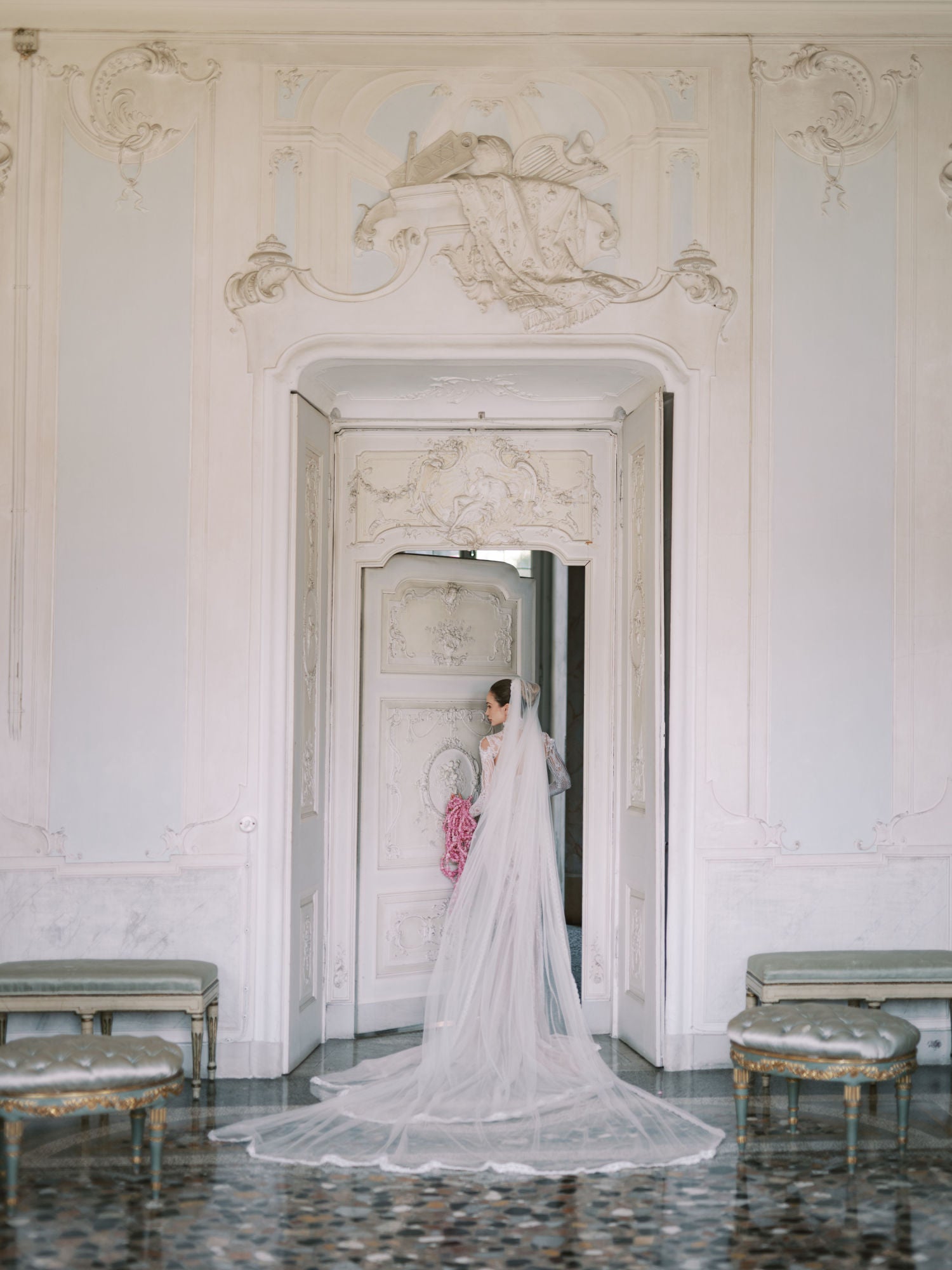 GL Bride Sarah in our Élysée standing in an elegant room with decorative walls.