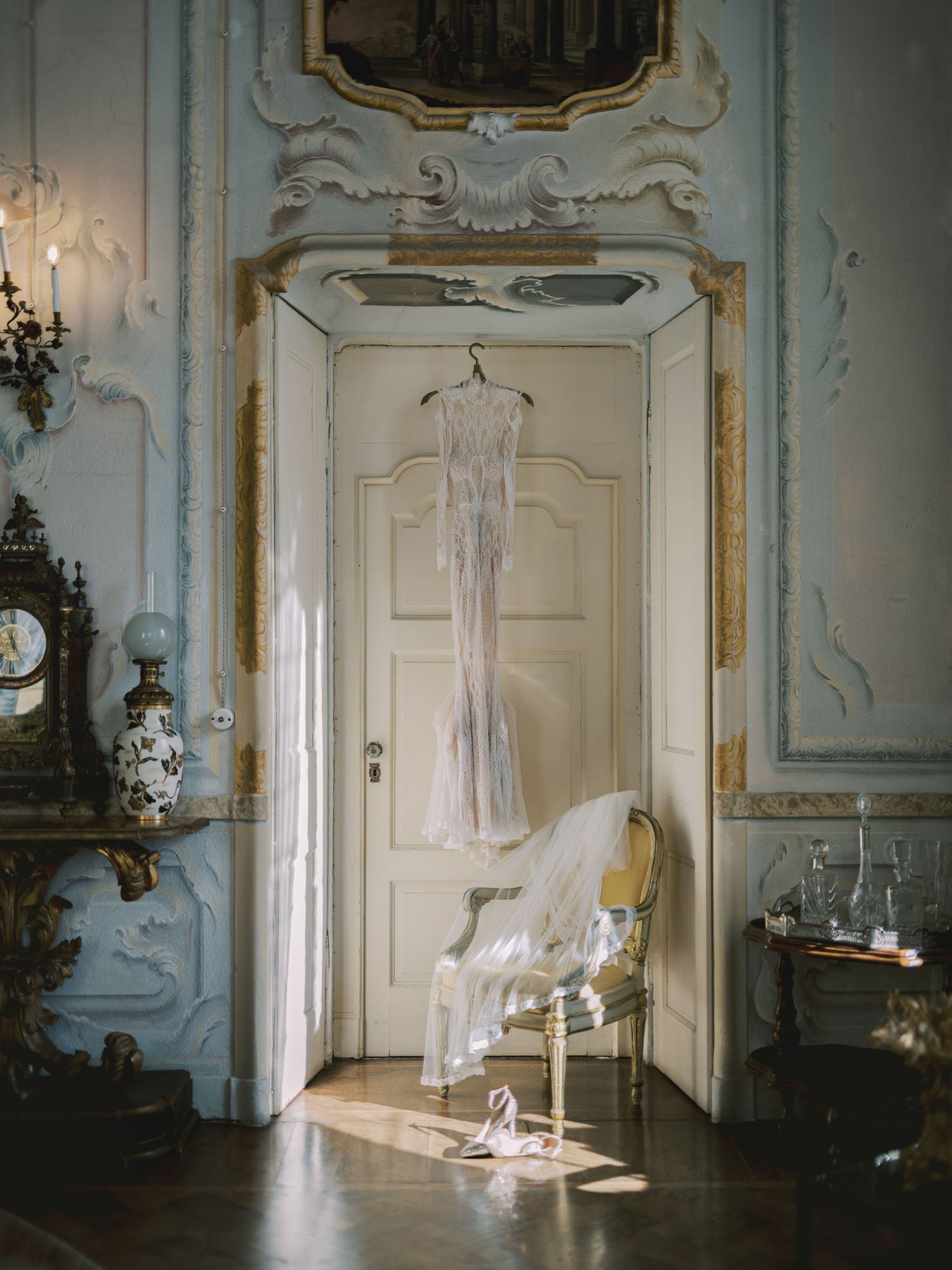 Élysée hanging up next to a chair in an ornate room with decorative walls.