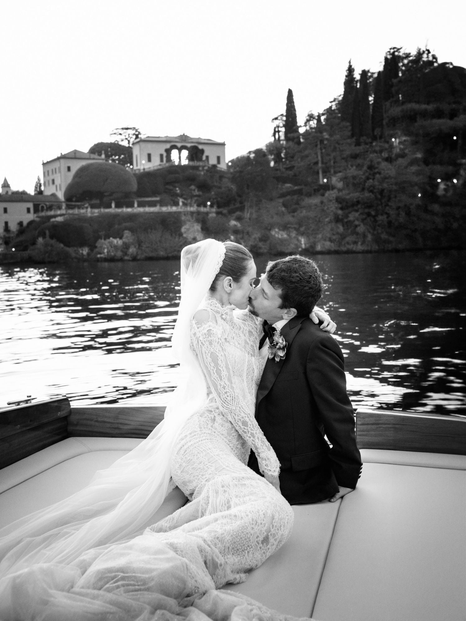 GL Bride Sarah in our Élysée with her groom, embracing on a boat with a scenic background