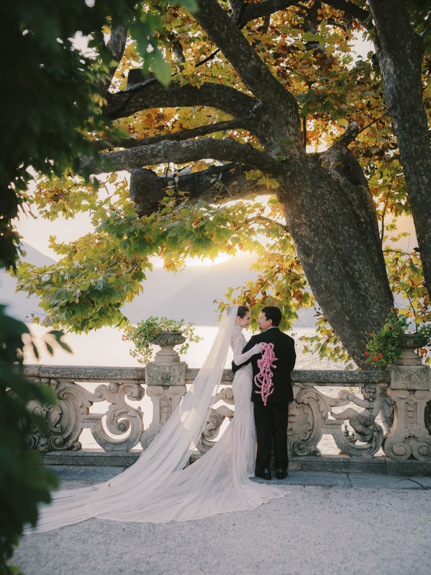 GL Bride Sarah Ingle in the Galia Lahav's Élysée  with her groom standing under a tree with a scenic background