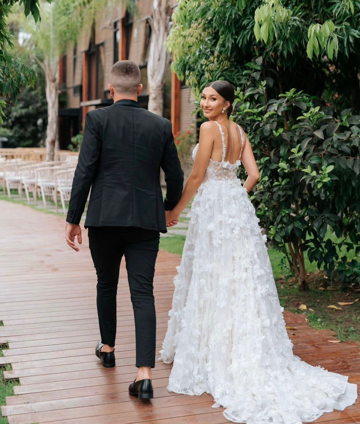 GL Bride Tanya wearing our Fabiana gown walking down the aisle with her groom