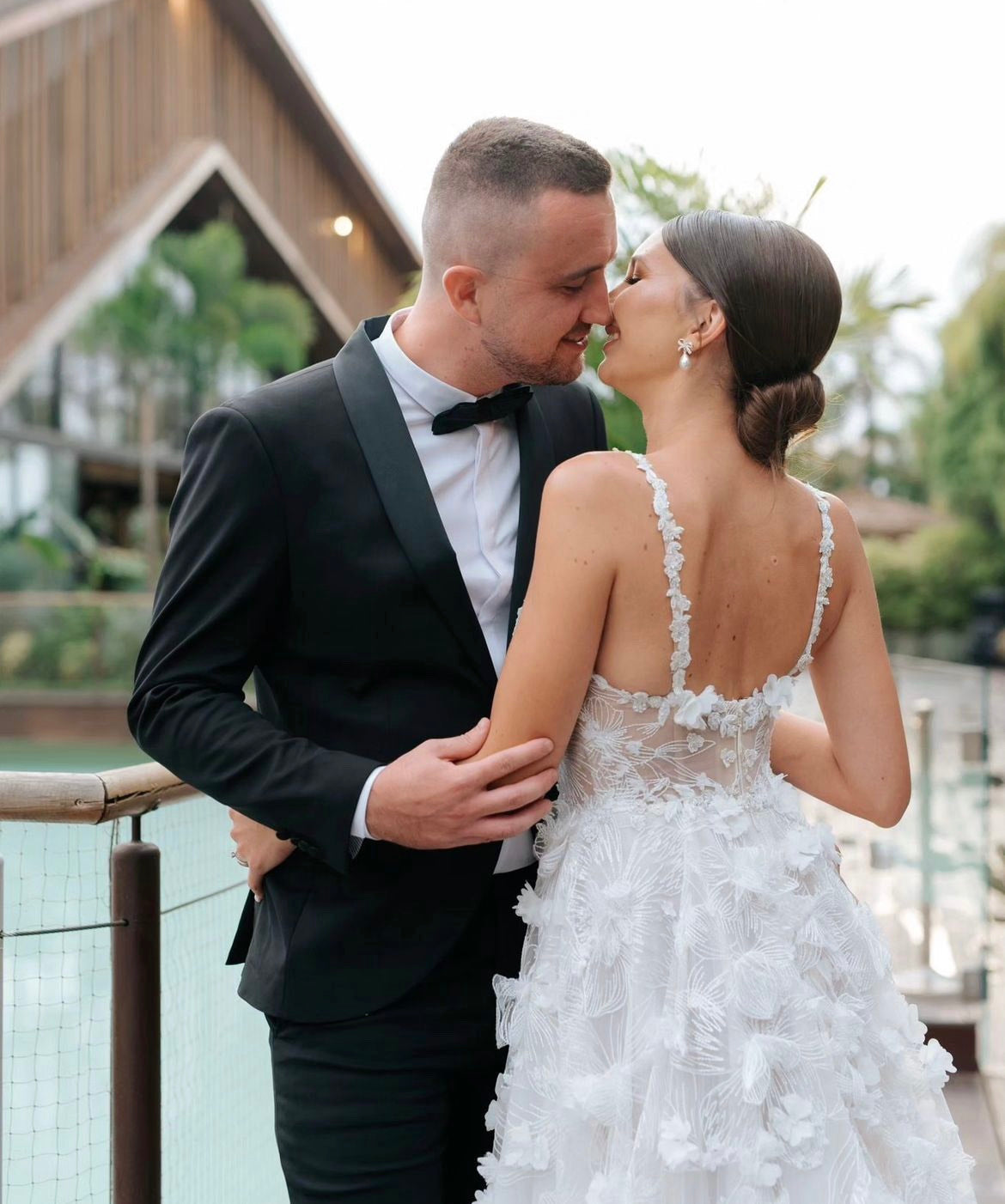 GL Bride Tanya wearing our Fabiana gown kissing her groom 