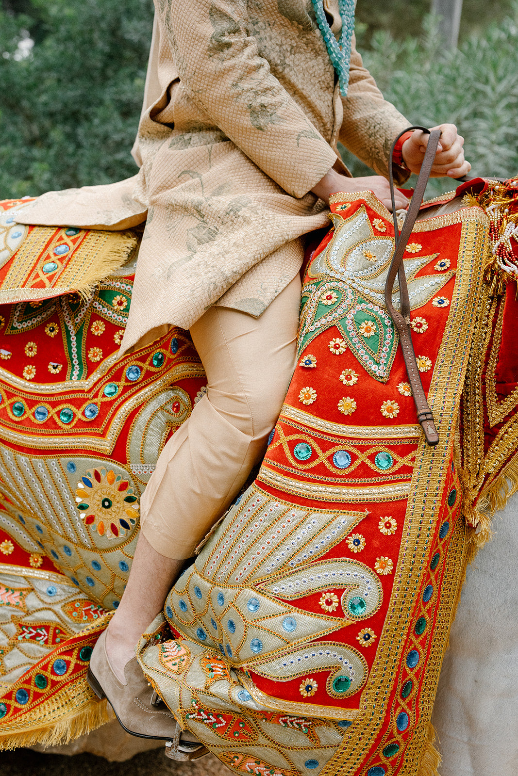 Groom sitting on a decorated horse with intricate patterns