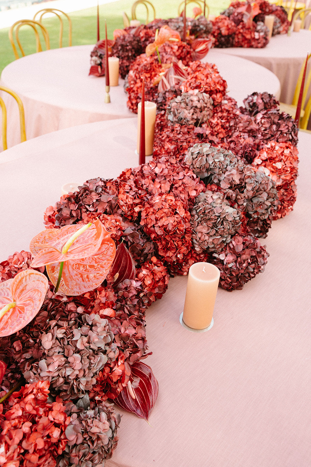 Decorative floral arrangement with red and pink flowers on a table.
