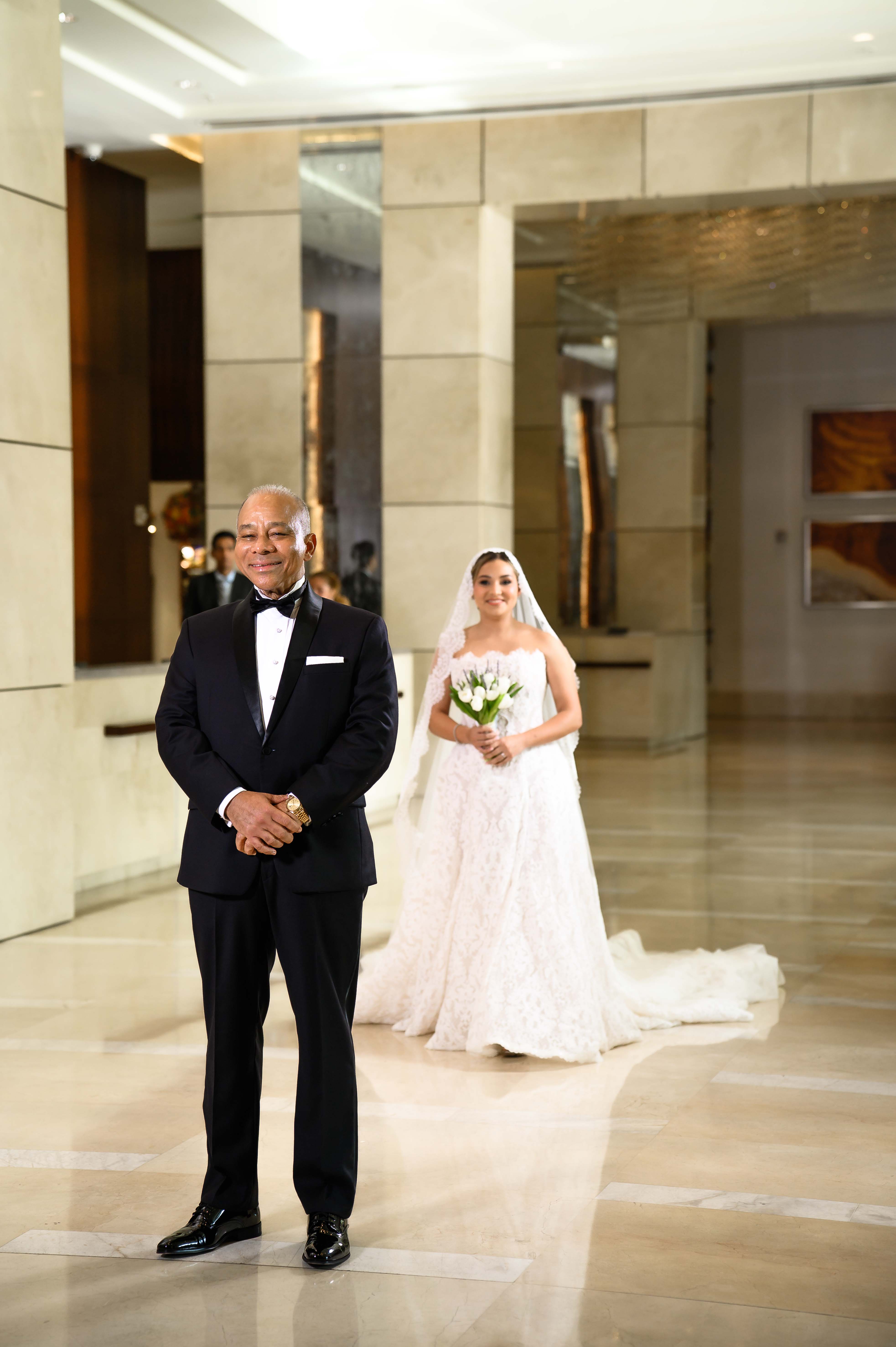 GL Bride Yamilca wearing our Splendid  in standing in a hallway, having first look with her father 