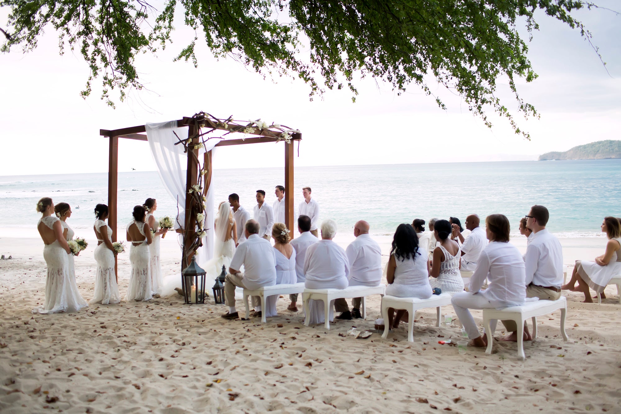 GL Bride Allie wearing our Loretta gown at the altar on the beach 