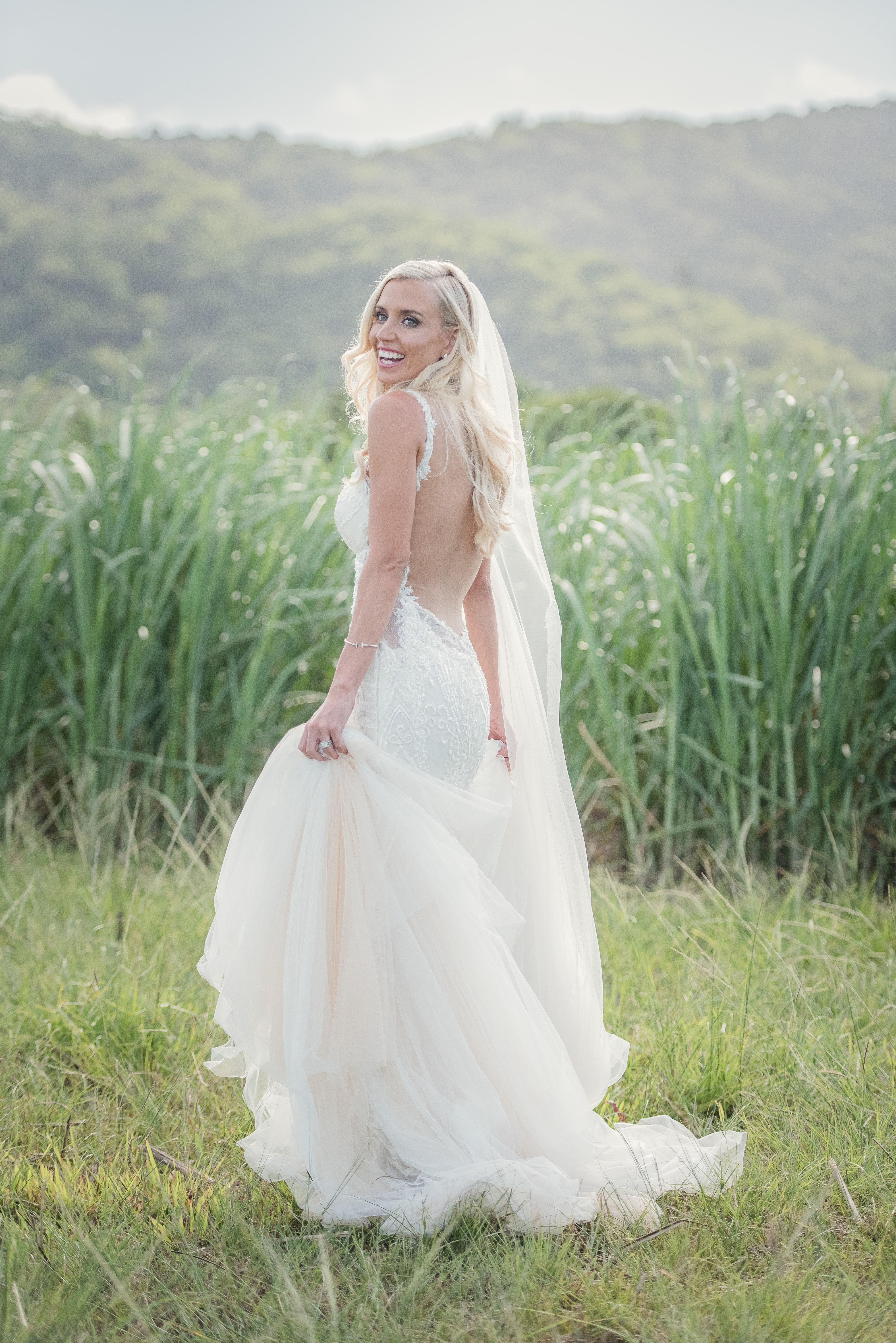 GL Bride Elise wearing our Greta Garbo Gown in an open green field 