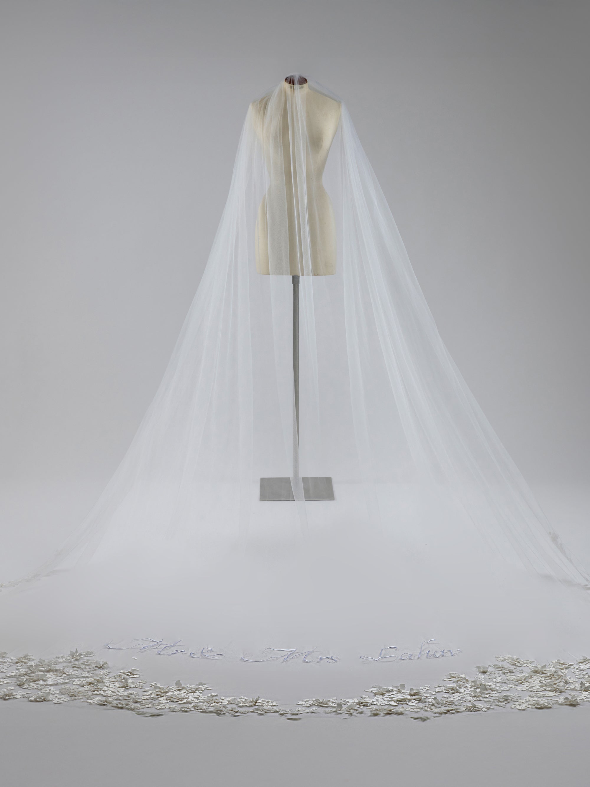 White wedding veil with a silver trim on a gray background