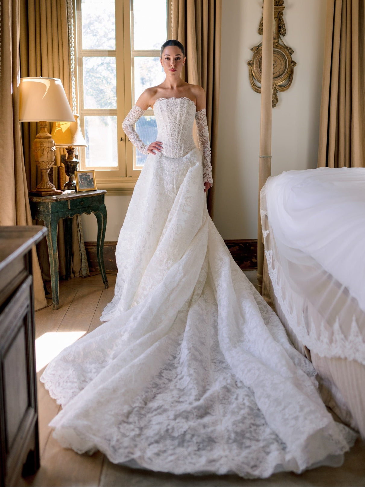 Woman in a white wedding dress holding a blue bouquet in a elegant room.